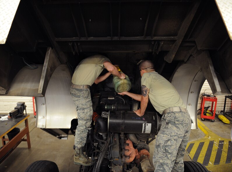 Airmen 1st Class Timothy Bailey and Troy Hammond, 2nd Logistics Readiness Squadron Firetruck and Refueling Maintenance Section, pours coolant in the radiator of a P-22 firetruck on Barksdale Air Force Base, La., March 20. The radiator circulates coolant throughout the vehicle to prevent overheating. (U.S. Air Force photo/Airman 1st Class Benjamin Gonsier)