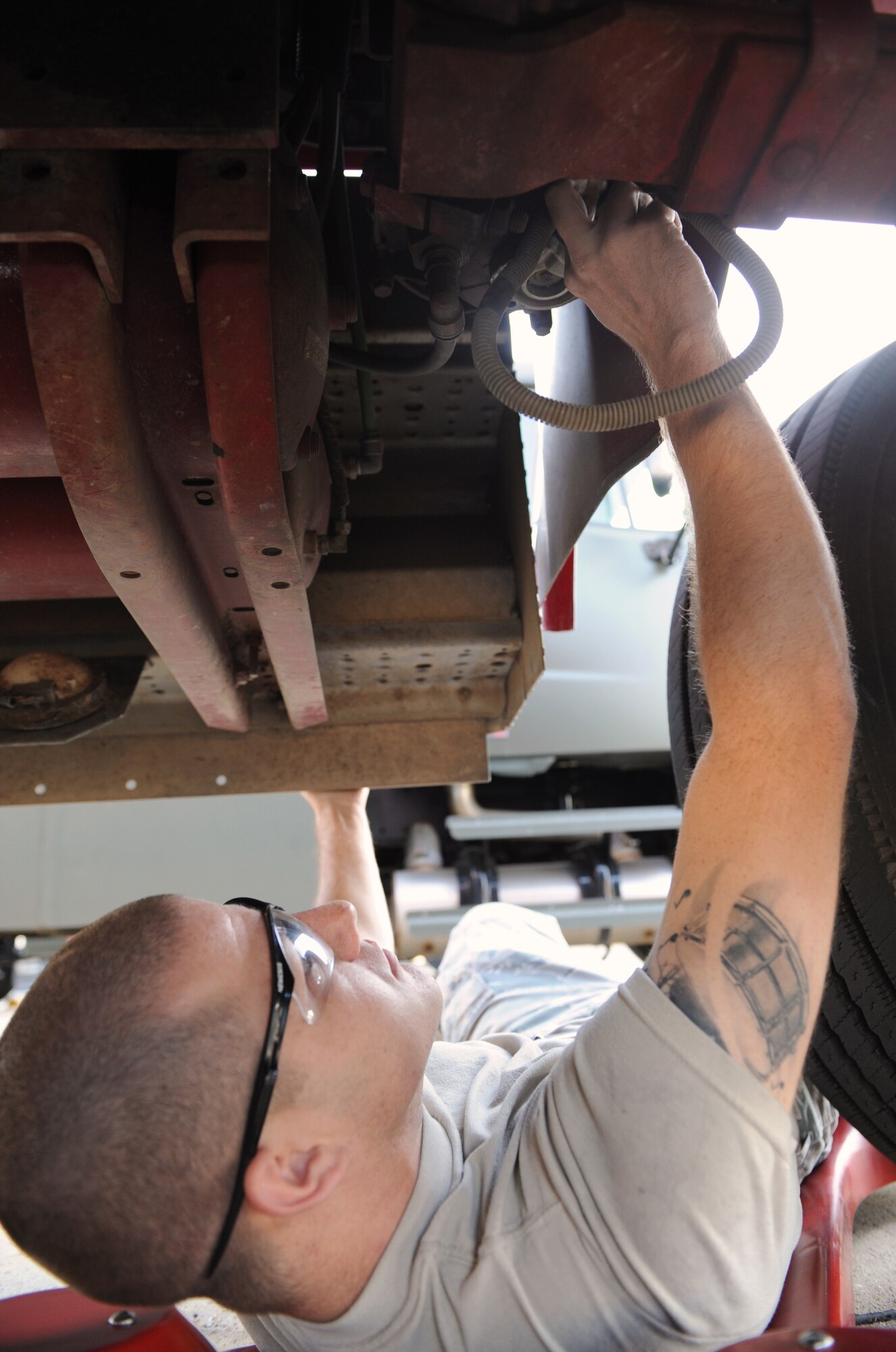 Airman 1st Class Troy Hammond, 2nd Logistics Readiness Squadron Firetruck and Refueling Maintenance Section, removes a purge valve underneath a rescue truck on Barksdale Air Force Base, La., March 20. The purge valve released excess moisture from the vehicles air system. (U.S. Air Force photo/Airman 1st Class Benjamin Gonsier)