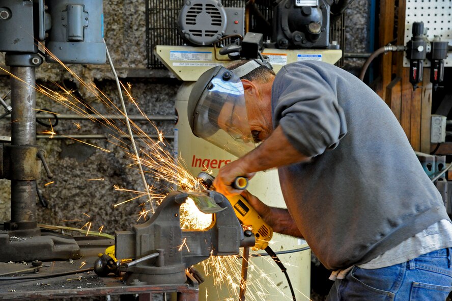 Lyle Miller, 2nd Force Support Squadron Equipment Rental, sharpens lawnmower blades with a grinder on Barksdale Air Force Base, La., March 20. Equipment Rental offers lawnmower repair for Team Barksdale as well as paintball equipment and serving as the sign up area for swimming lessons during the summer months. (U.S. Air Force photo/Airman 1st Class Andrew Moua)