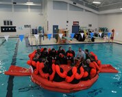 HUBBARD COMMUNITY POOL, Ohio -- Members of the 910th Operations Group sit aboard a life raft during a water survival training class here, March 3, 2013. The course allows members to fulfill their annual requirement to refresh the skills needed in case their aircraft goes down over land or water. Coursework includes segments covering map reading, compass use, food and water procurement, survival vest use, signaling and water survival training.