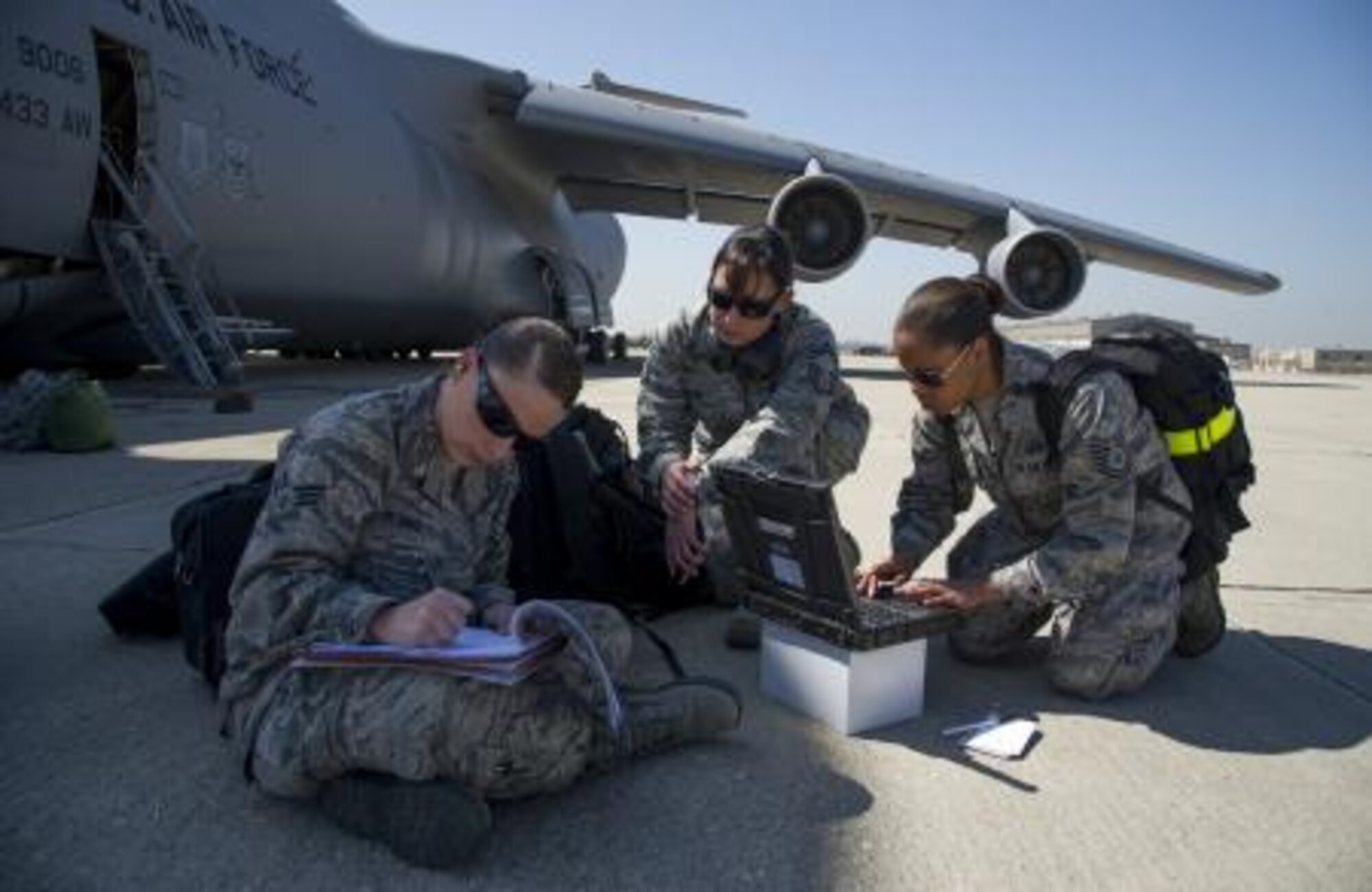 Senior Airman Amy Dennis, Senior Master Sgt. Lisa Deleon and Tech Sgt. Candice Taylor with the 433rd Airlift Control Flight make initial contact with headquarters immediately after landing at Los Alamitos Army Air Field, Calif., during Patriot Hook March 12, 2013. Patriot Hook is an Air Force Reserve Command sponsored exercise that focuses on maximizing the operational utilization for all participants in achieving fully integrated air mobility training objectives. (U.S. Air Force photo by Tech. Sgt. Bradley Church)