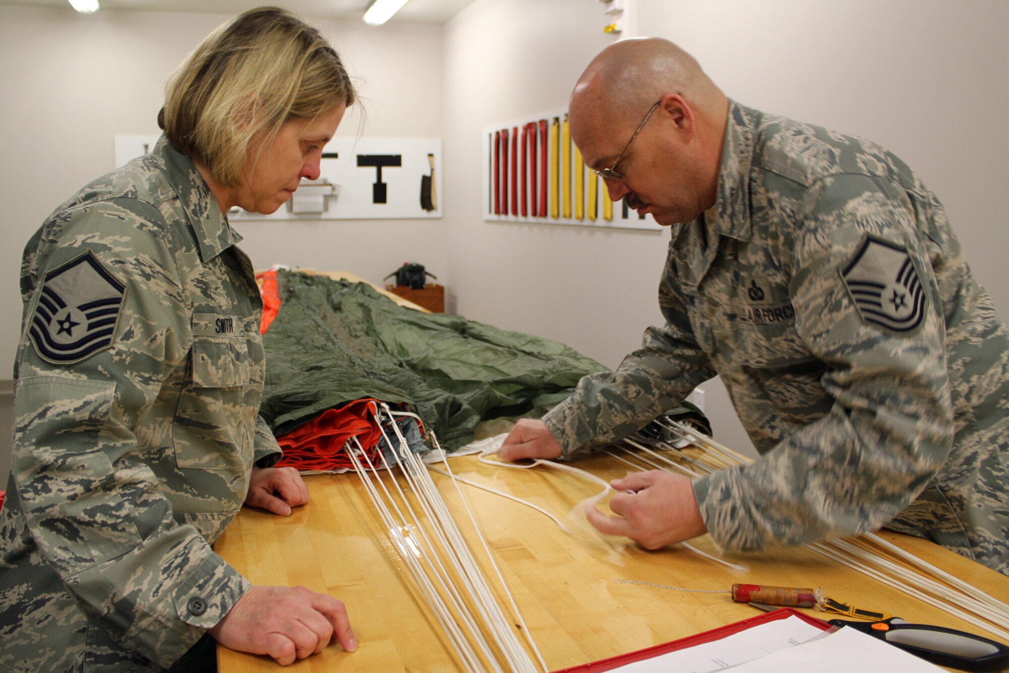 130319-Z-VA676-026 - Master Sgt. Kathy Smith watches as Master Sgt. Ed Stone makes a repair to a piece of parachute cord during an inspection of an ACES II C-9 canopy parachute at Selfridge Air National Guard Base, Mich., March 19, 2013. Air Force parachutes are inspected at least annually and then re-packed. Stone and Smith are members of the aircrew flight equipment shop of the 127th Operations Support Flight, a component of the 127th Wing, Michigan Air National Guard. (Air National Guard photo by TSgt. Dan Heaton)