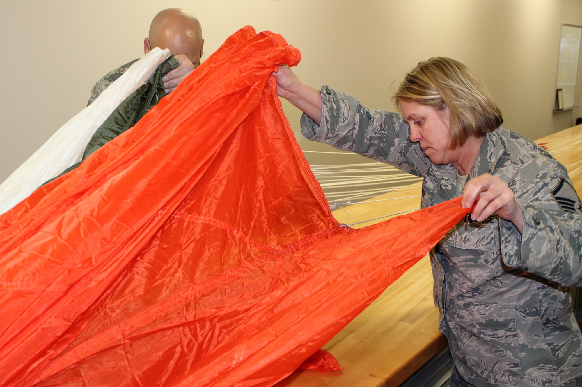 130319-Z-VA676-002 - Master Sgt. Kathy Smith and Master Sgt. Ed Stone (partially hidden) inspect an ACES II C-9 canopy parachute at Selfridge Air National Guard Base, Mich., March 19, 2013. Air Force parachutes are inspected at least annually and then re-packed. Stone and Smith are members of the aircrew flight equipment shop of the 127th Operations Support Flight, a component of the 127th Wing, Michigan Air National Guard. (Air National Guard photo by TSgt. Dan Heaton)