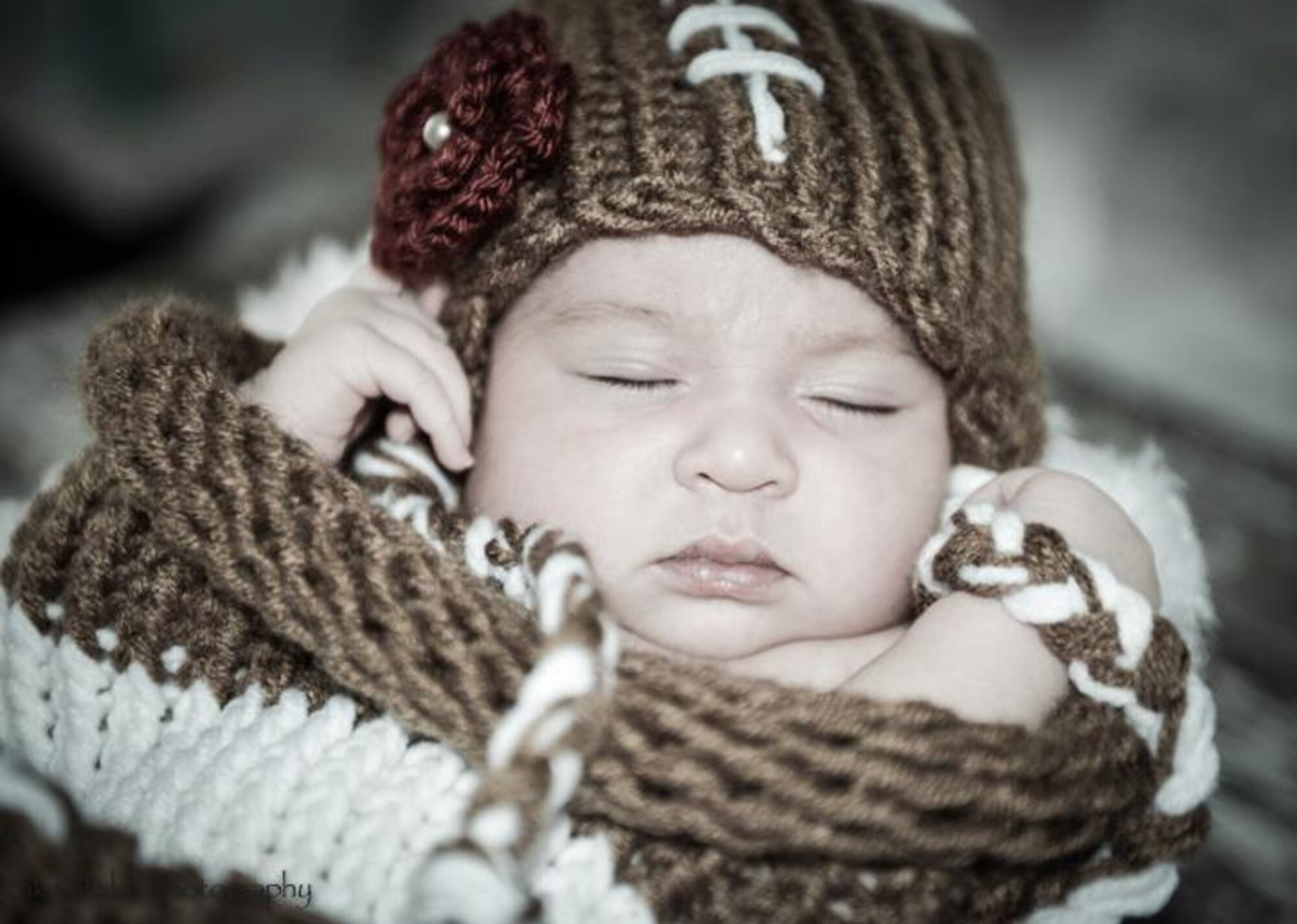 Alexis Quinn, daughter of Tech. Sgt. Ruben TrejoSanchez, 493rd Aircraft Maintenance Unit NCO in charge of weapons maintenance, and Tech. Sgt. Patti TrejosSanchez, 48th Medical Support Squadron transfusion service NCO in charge, sleeps in a knitted football costume. Alexis was delivered at home by her father the night of the Super Bowl. (Photo by Tech. Sgt. Jamie Olguin) 