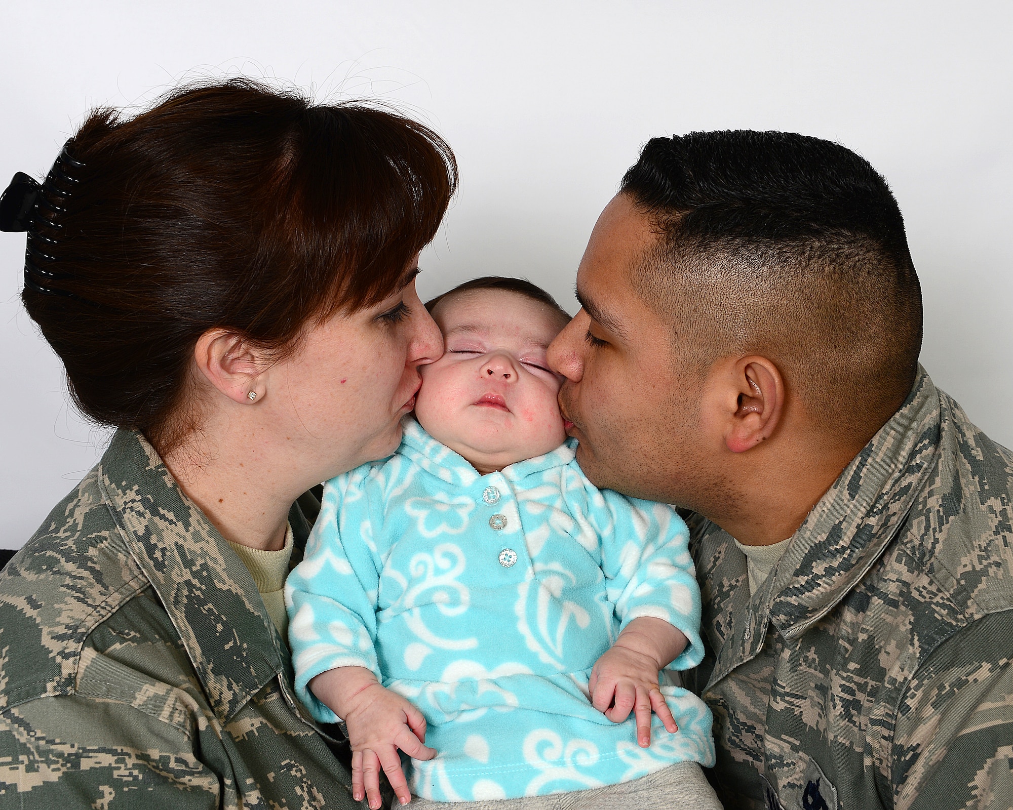 ROYAL AIR FORCE LAKENHEATH, England – Tech. Sgt. Ruben TrejoSanchez, 493rd Aircraft Maintenance Unit NCO in charge of weapons maintenance, and Tech. Sgt. Patti TrejosSanchez, 48th Medical Support Squadron transfusion service NCO in charge, kiss their baby, Alexis Quinn March 19, 2013. Ruben TrejoSanchez delivered his baby at home during Super Bowl weekend. (U.S. Air Force photo by Staff Sgt. Stephanie Mancha)