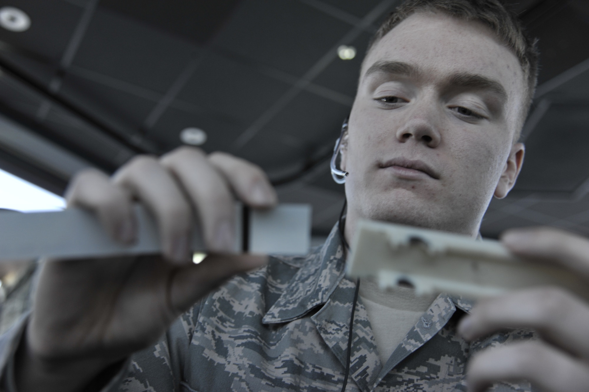 Airman 1st Class Seth Lewis, 509th Operations Support Squadron air traffic control apprentice, slides a flight strip into a holder at Whiteman Air Force Base, Mo., March 11, 2013. A flight strip is used for flight planning to tell route of flight. It also tracks the arrival and departure times. (U.S. Air Force photo by Airman 1st Class Keenan Berry/Released) 