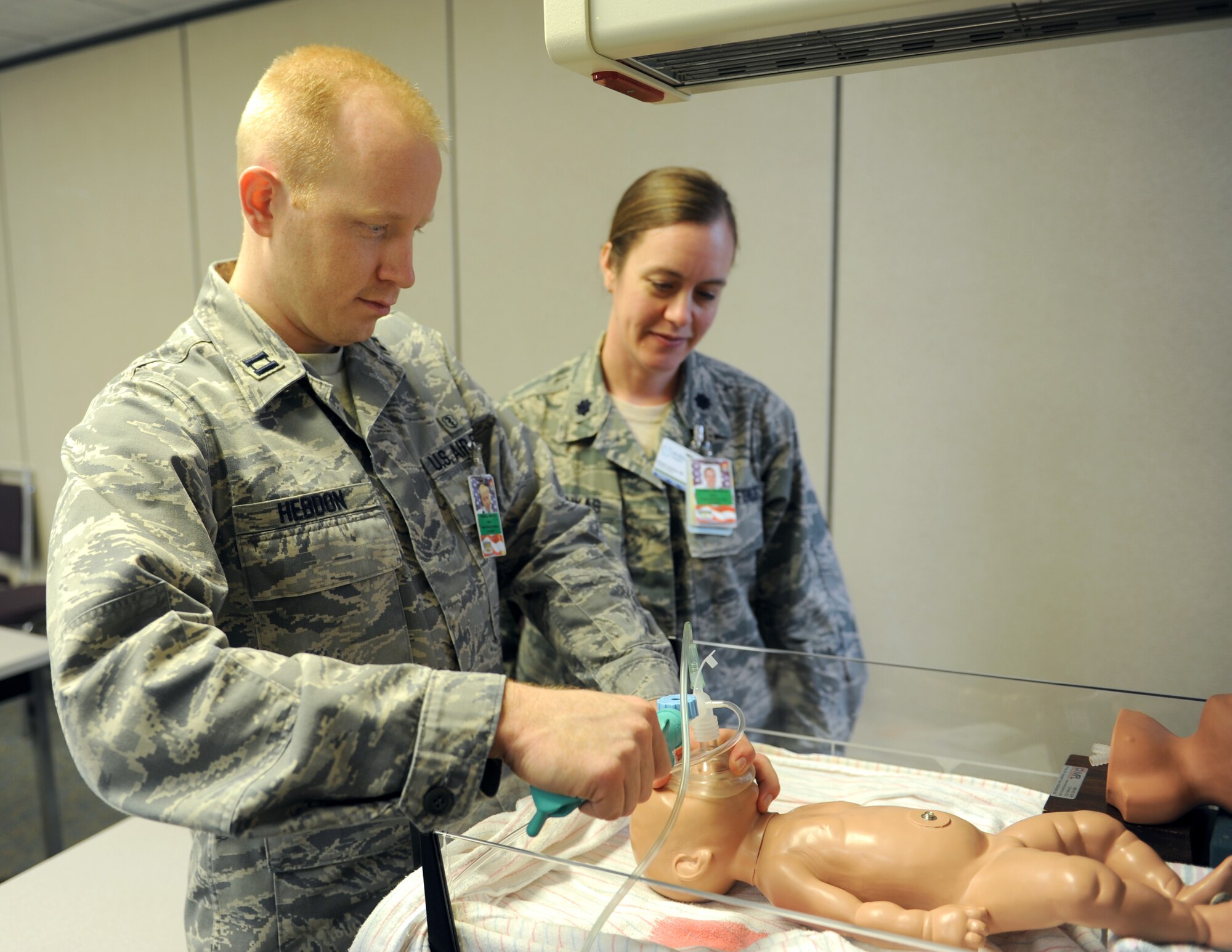 Lt. Col. Kirsten Vitrikas, Scott AFB Family Medicine Residency military program director, watches Capt. Adam Hebdon, a third-year resident , as he practices neonatal resuscitation during a simulation exercise March 11 at St. Louis University Family Medicine in Belleville, Ill.  This exercise helps residents simulate the steps they must take when a baby doesn't breath when he or she is born.  (U.S. Air Force photo/Staff Sgt. Maria Bowman)