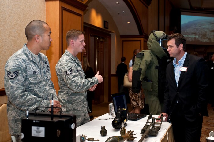 Staff Sgt. Matthew Hulsman, 99th Civil Engineer Squadron explosive ordinance disposal technician, speaks to Nathan Richter, Director of Rental Sales for Hilton Grand Vacations during a Las Vegas Chamber of Commerce luncheon March 20, 2013, at Texas Station Hotel and Casino in Las Vegas. Airmen from EOD were on hand to demonstrate the various tools and equipment the Air Force uses during missions. (U.S. Air Force photo by Airman 1st Class Jason Couillard)