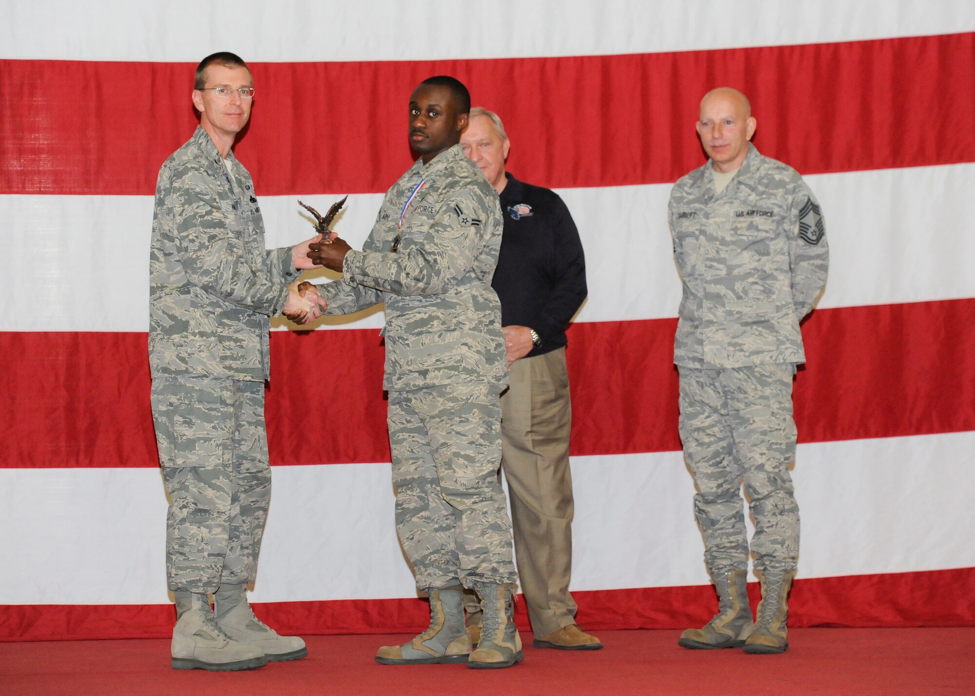 Airman 1st Class Derek Adu, 325th Maintenance Operations Squadron, receives the award for Air Combat Command Analysis of the Year Maintenance Manager of the Year in the Airman category from Col. Curtis Hafer, 325th Maintenance Group commander, and Chief Master Sgt. Terry Gabbert, 325th MXG superintendent, and retired ninth Chief Master Sergeant of the Air Force, Chief Master Sgt. James Binnicker, during the 2012 Maintenance and Staff Professionals of the Year banquet in Hangar 1 March 15. The MPOY banquet recognizes the achievements of the maintenance group and honors maintenance professionals each year. (U.S. Air Force photo by Chris Cokeing)