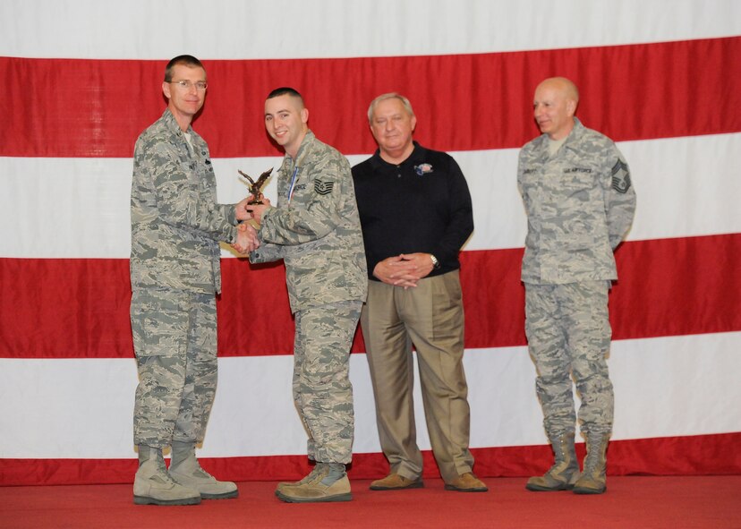 Tech. Sgt. Robert Scruggs, 325th Maintenance Operations Squadron, receives the award for Air Combat Command Maintenance Training Flight Instructor of the Year from Col. Curtis Hafer, 325th Maintenance Group commander, and Chief Master Sgt. Terry Gabbert, 325th MXG superintendent, and retired ninth Chief Master Sergeant of the Air Force, Chief Master Sgt. James Binnicker, during the 2012 Maintenance and Staff Professionals of the Year banquet in Hangar 1 March 15. The MPOY banquet recognizes the achievements of the maintenance group and honors maintenance professionals each year. (U.S. Air Force photo by Chris Cokeing)