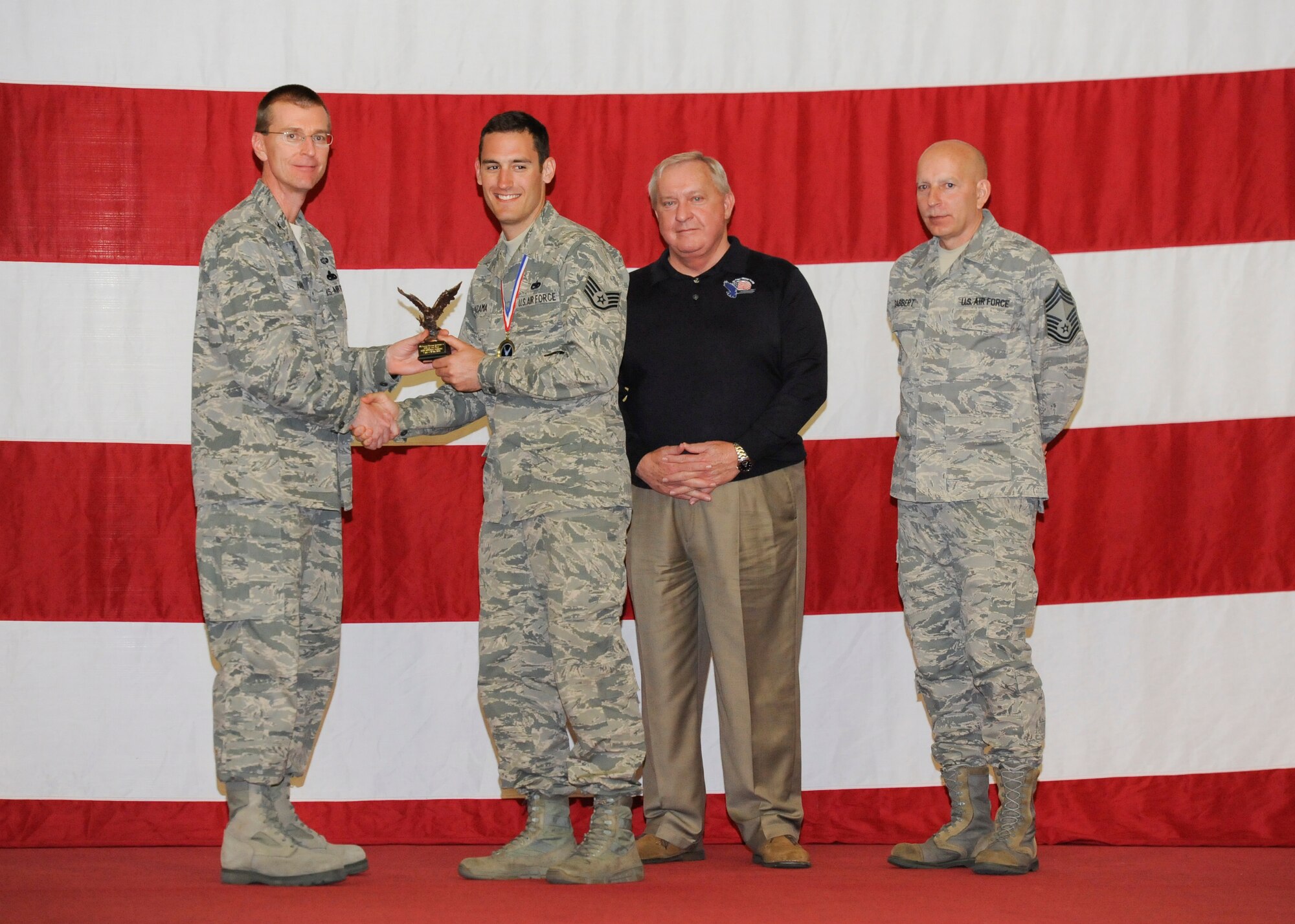 Staff Sgt. Michael Sazama, 372nd Training Squadron, Det. 4, receives the award for Detachment NCO of the Year from Col. Curtis Hafer, 325th Maintenance Group commander, and Chief Master Sgt. Terry Gabbert, 325th MXG superintendent, and retired ninth Chief Master Sergeant of the Air Force, Chief Master Sgt. James Binnicker, during the 2012 Maintenance and Staff Professionals of the Year banquet in Hangar 1 March 15. The MPOY banquet recognizes the achievements of the maintenance group and honors maintenance professionals each year. (U.S. Air Force photo by Chris Cokeing)