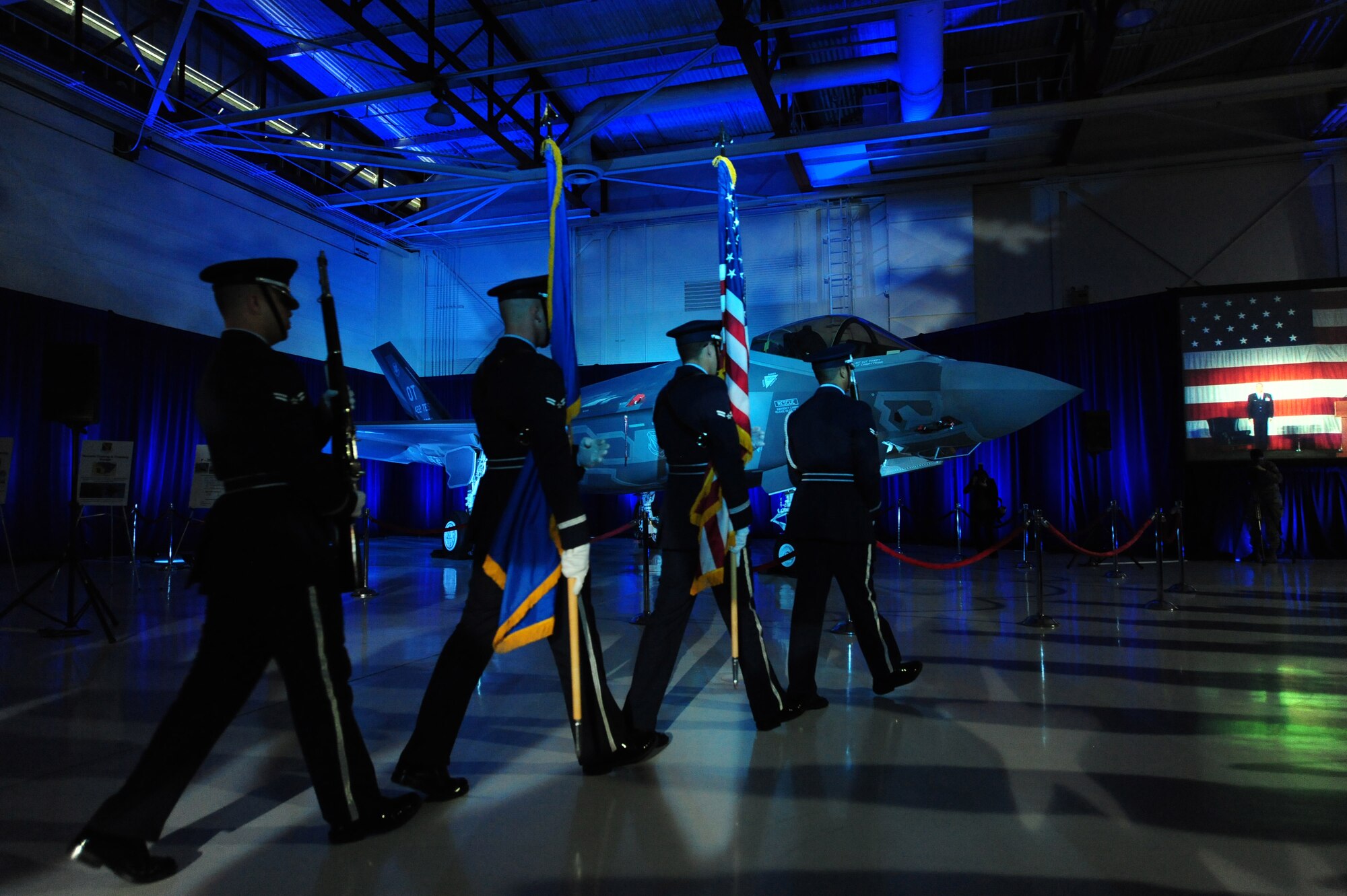The Nellis Air Force Base Honor Guard marches towards the stage to post the colors at the F-35A Lighting II arrival ceremony March 19, 2013, in the Thunderbird Hangar at Nellis Air Force Base, Nev. The 422nd Test and Evaluation Squadron will design tactics for the F-35 and determine how to integrate it with other aircraft in the Air Force inventory. (U.S. Air Force photo by Staff Sgt. William P. Coleman)