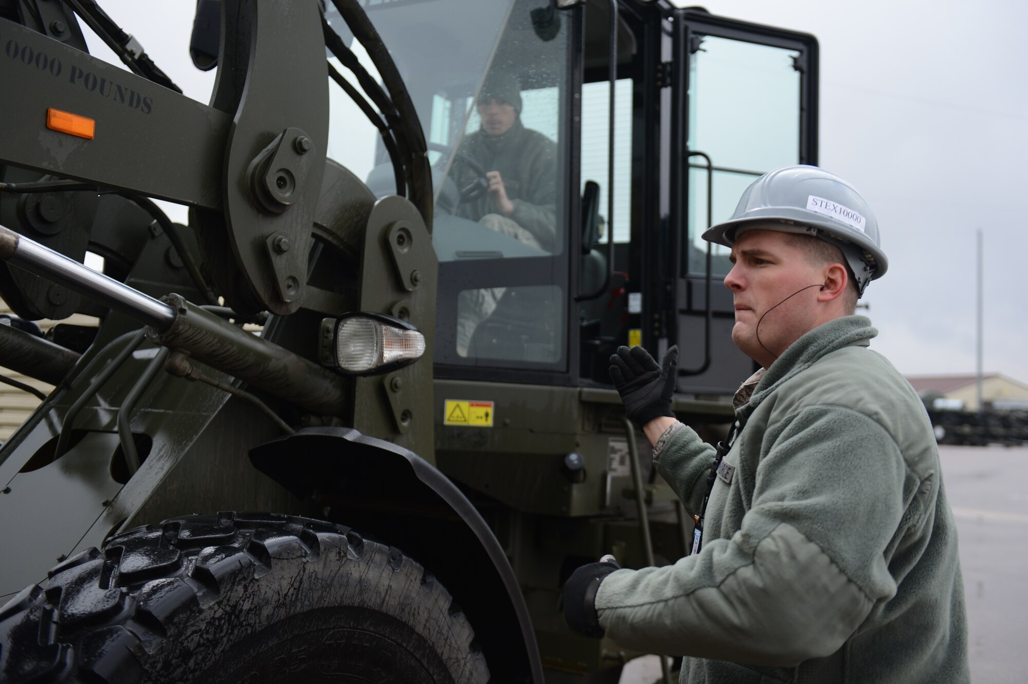 SPANGDAHLEM AIR BASE, Germany – U.S. Air Force Staff Sgt. Zachary Zeman, 52nd Equipment Maintenance Squadron munitions storage crew chief from Lone Tree, Iowa, gives direction to U.S. Air Force Senior Airman Dillon Meredith, 52nd EMS storage crew chief from Green Bare, Calif., while operating an all-terrain forklift to move intermodal shipping containers near the ammunition bomb dump March 19, 2013. The vehicle is capable of lifting and carrying 10,000 pounds safely. Airmen from the 52nd EMS are assisting in the transportation of the ISOs to Miesau Army Depot as part of a Major Command directed munitions movement plan. (U.S. Air Force photo by Airman 1st Class Gustavo Castillo/Released)