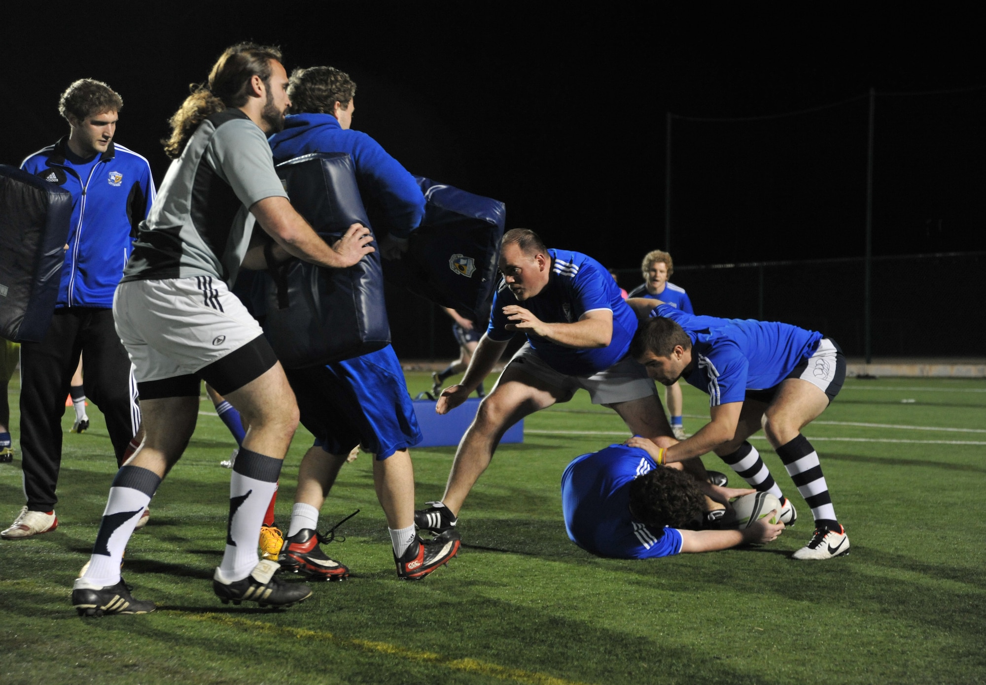 Jordan Winemiller, fourth from right, Kansas City Blues Rugby Club player, braces for a tackle during practice in Kansas City, Mo., March 14, 2013. As the only professionally-backed rugby sporting club in the country, the Blues expect its players to practice hard and play hard in all weather conditions. (U.S. Air Force photo by Senior Airman Brigitte N. Brantley/Released)