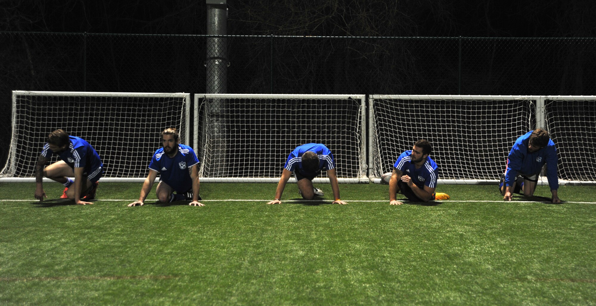 Players from the Kansas City Blues Rugby Club stretch before a two-hour practice in Kansas City, Mo., March 14, 2013. The variety of professions on this team, including lawyers, molecular biology engineers, and Soldiers and Airmen, is a testament to the widespread appeal of the sport. (U.S. Air Force photo by Senior Airman Brigitte N. Brantley/Released)