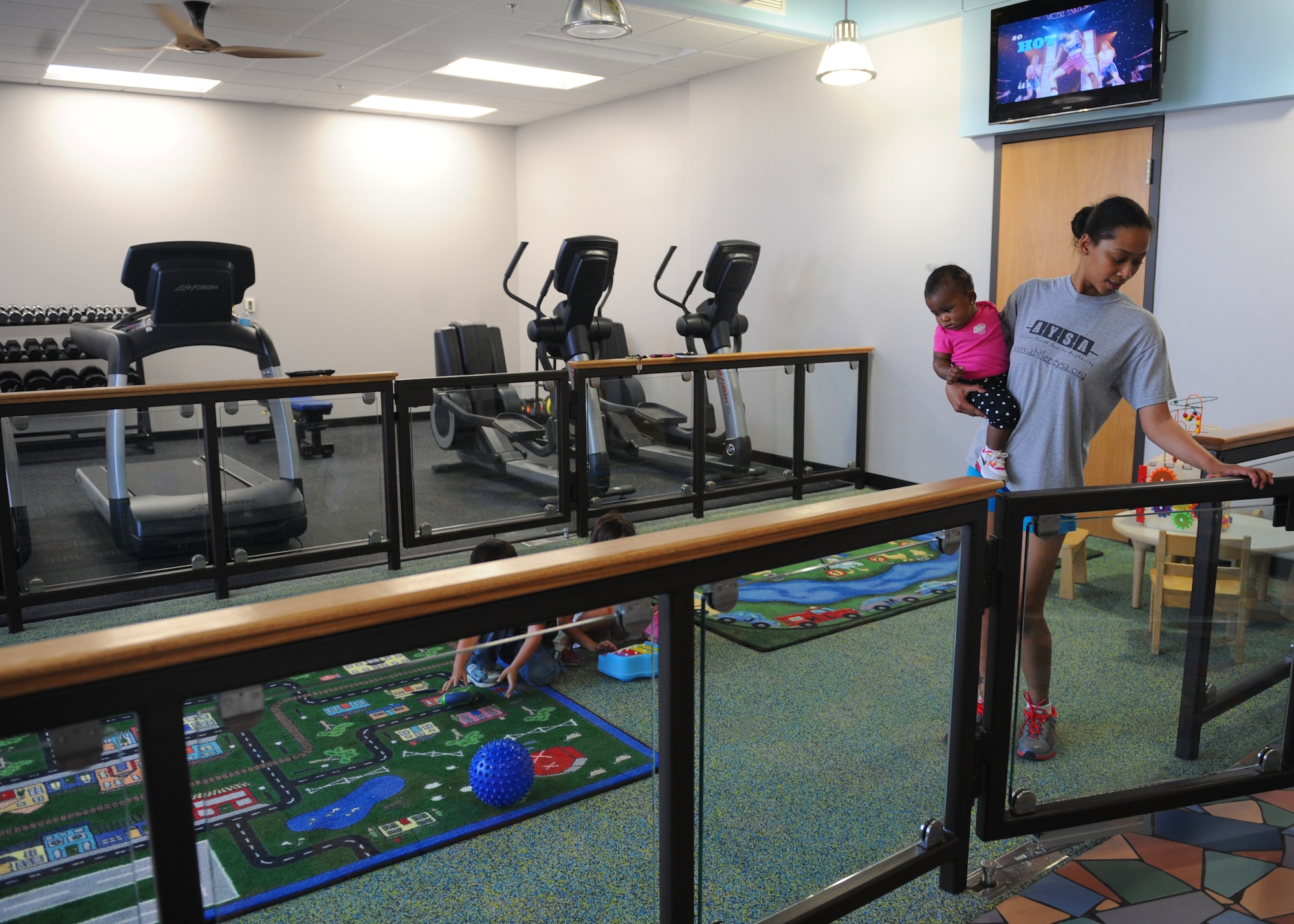 Senior Airman Zaneta Jackson, 7th Force Support Squadron, and her daughter Zalayiah, enter the new Parent Child Activity room at the Dyess Fitness Center, March 15, 2013, at Dyess Air Force Base, Texas. The new activity room is twice the size of the old room and has a maximum capacity of eight children and eight adults. (U.S. Air Force photo by Airman 1st Class Cierra Presentado/Released)