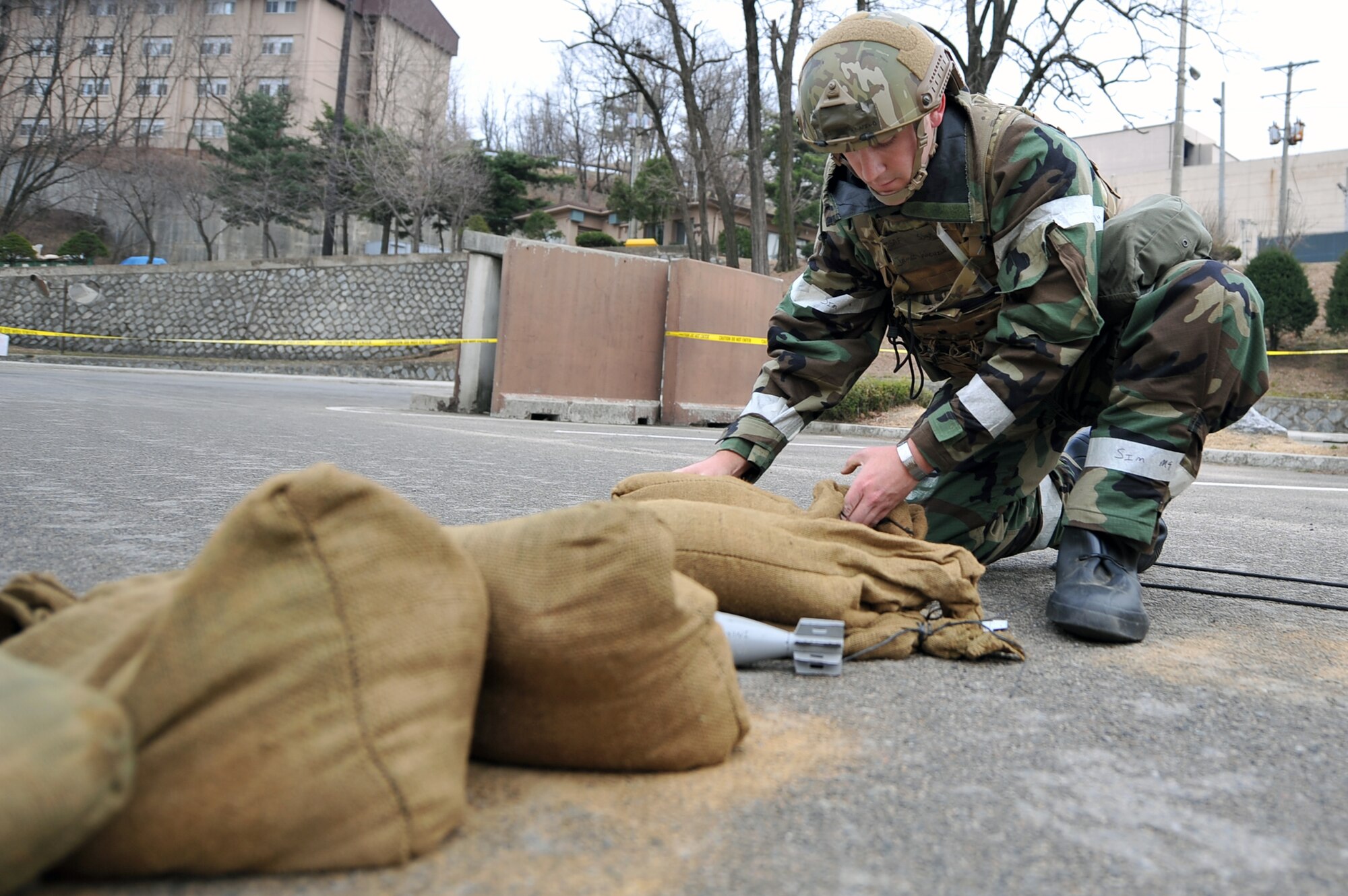 51st Civil Engineer Squadron Explosive Ordnance Disposal craftsman, positions a tool to detonate a simulated 16 millimeter mortar for removal during Operational Readiness Exercise Beverly Midnight 13-02 outside Bldg. 839 at Osan Air Base, Republic of Korea, March 20, 2013. These exercises tests Osan Airmen’s abilities during a heightened state of readiness while providing combat ready forces for close air support, air strike control, counter air, interdiction, theater airlift, and communications in the defense of the Republic of Korea. (U.S. Air Force photo/Senior Airman Alexis Siekert)