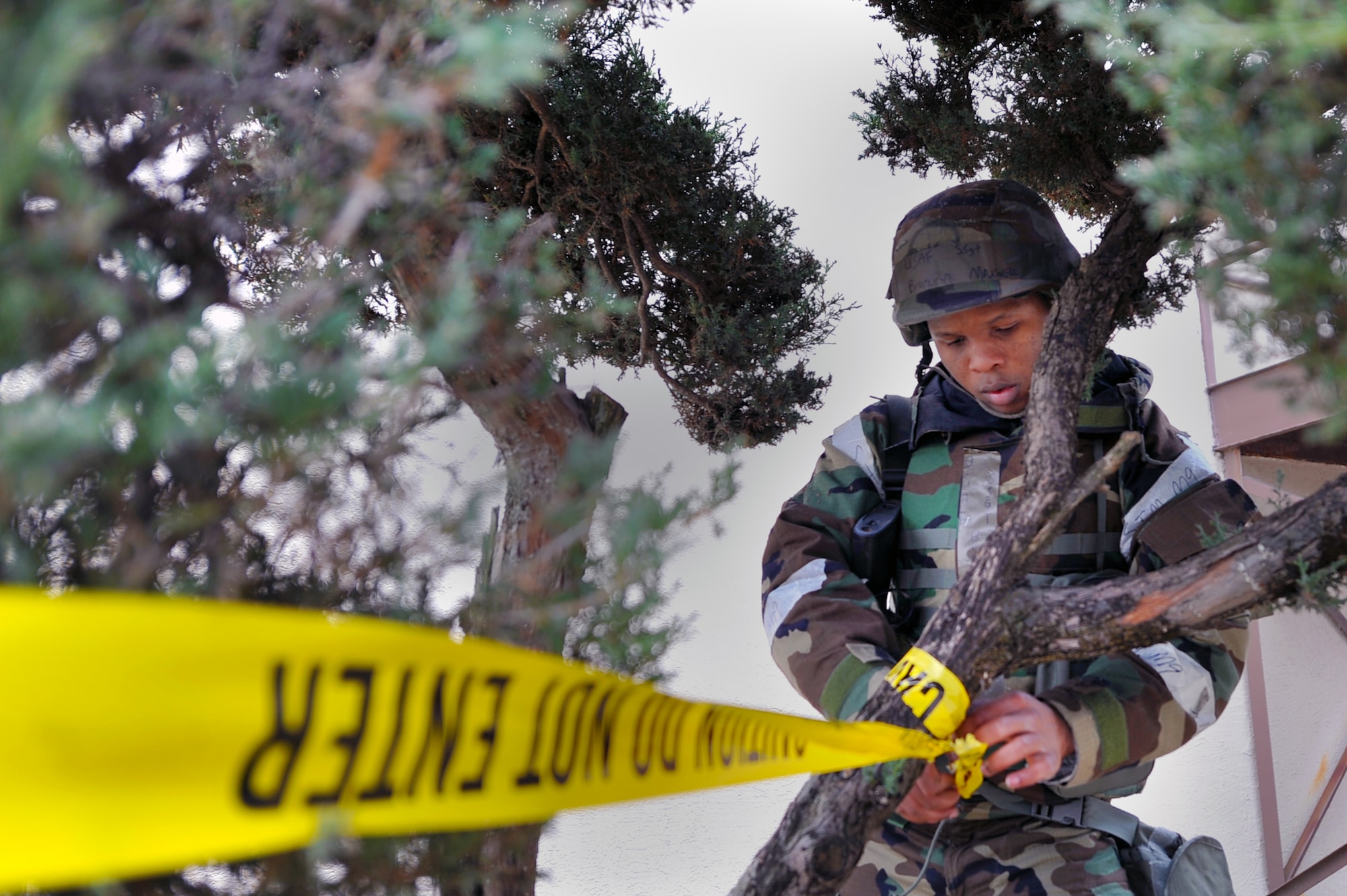 Staff Sgt. Brandon Maxwell, 51st Comptrollers Squadron relocation technician, ties caution tape to a tree while setting up a cordon for simulated unexploded ordnance during Operational Readiness Exercise Beverly Midnight 13-02 at Osan Air Base, Republic of Korea, March 20, 2013. Throughout the week, Airmen undergo several different scenarios that will test their ability to defend the base and conduct daily operations during a heightened state of readiness. (U.S. Air Force photo/Senior Airman Alexis Siekert)