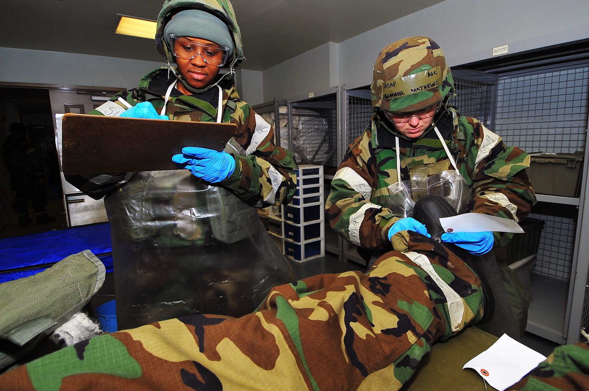 Senior Airman Raashida Wise (left), 51st Force Support Squadron fitness specialist and Airman 1st Class Summer Mathews, 51st Force Support Squadron food service journeyman, tag remains of a mock fallen Airman with information from the  death certificate during Operational Readiness Exercise Beverly Midnight 13-02 at Bldg.  772 at Osan Air Base, Republic of Korea, March 20, 2013.  This is Osan’s third simulated wartime contingency exercise in 2013 that tests the base’s ability to defend and execute the mission in a heightened state of readiness.  (U.S.  Air Force photo/Staff Sgt. Emerson Nuñez) 