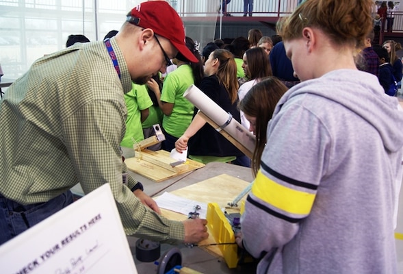 Tulsa District engineer helps students Jillian Newfield and Emily Cook make adjustments to their Ping-Pong Launcher before they competed in the event at the 25th Tulsa Engineering challenge March 8, at the Tulsa, Okla. Technology Center.