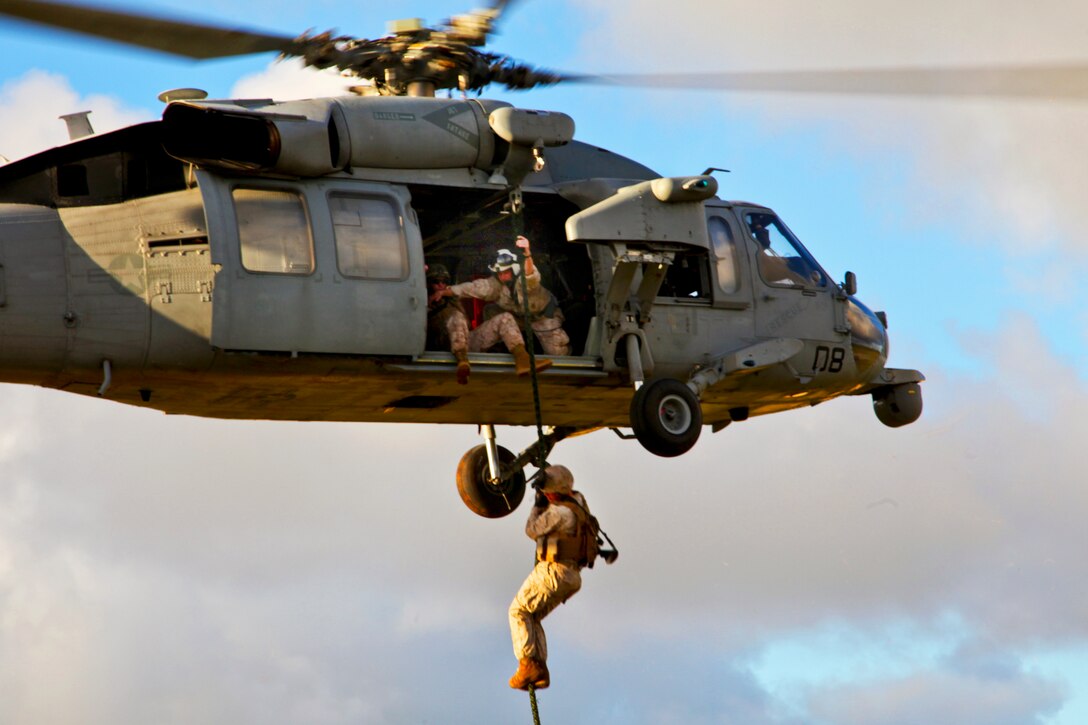 Marines fast-rope from an MH-60S Knighthawk helicopter and set up a ...