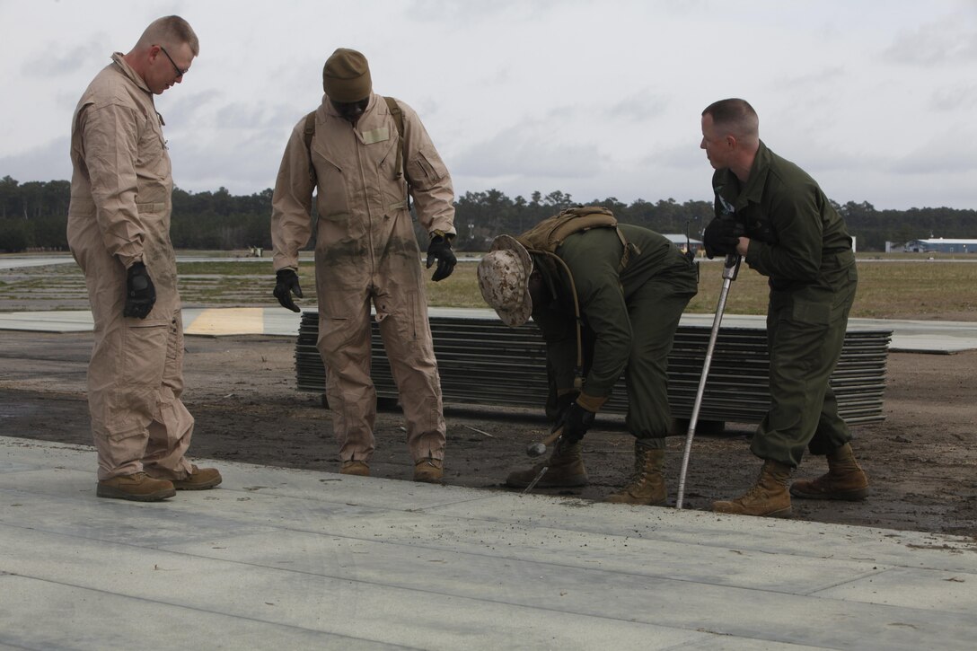 Marine Wing Support Squadron 271 engineers lift a 155-pound piece of aluminum matting on the  flight line at Marine Corps Auxiliary Landing Field Bogue March 18. The Marines will replace approximately 200,000 square feet of matting during the upgrade.