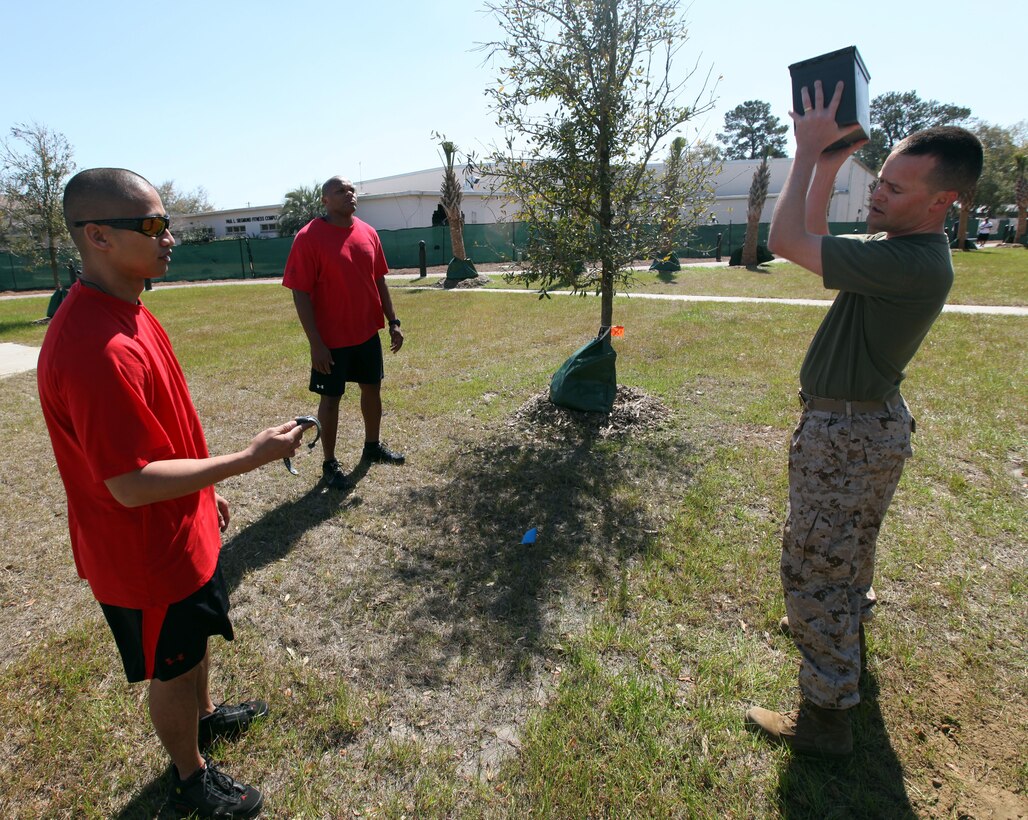 Lt. Twig Sergeant, Air Station staff chaplain, executes 20 ammo can lifts during the Warrior Challenge March 13. The Warrior Challenge is similar to a modified combat fitness test and has aspects of the High Intensity Tactical Training program.