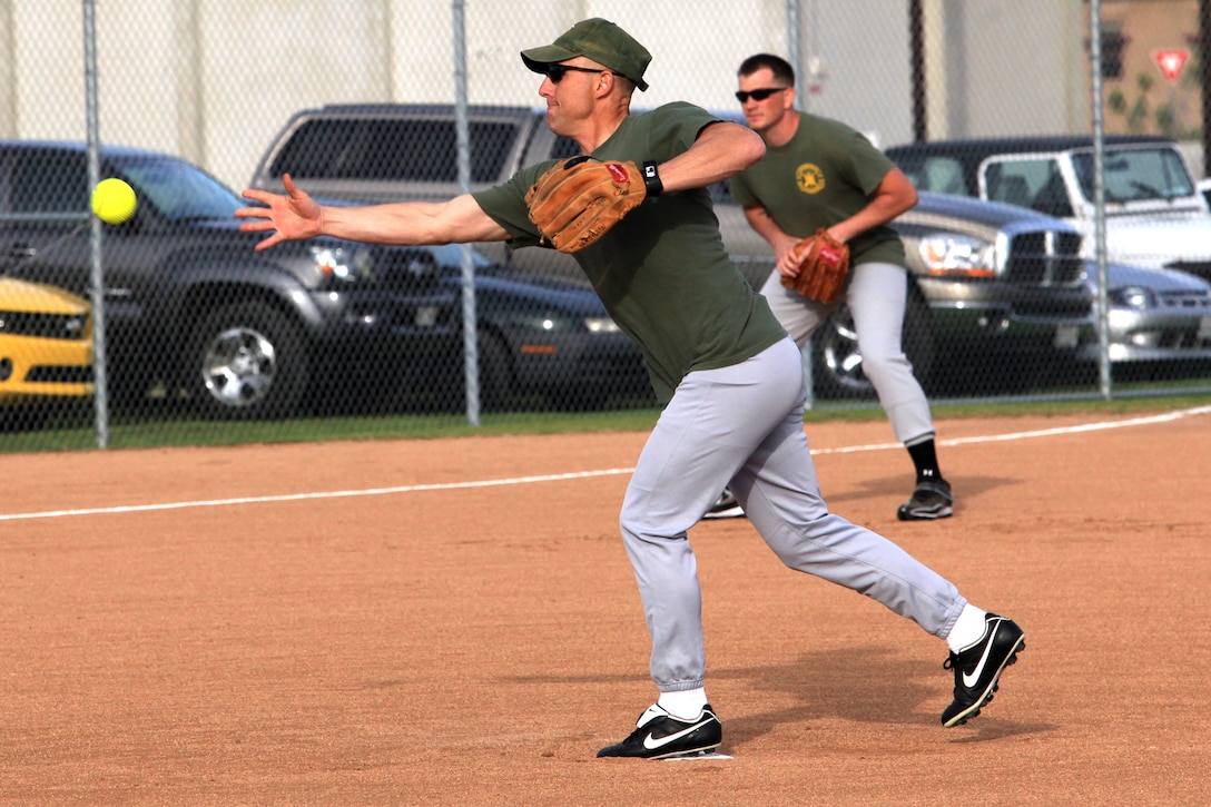 Sgt. Maj. Adam Yakubsin, the battalion sergeant major for 1st Intelligence Battalion, from Gainesville, Fla., throws a pitch during the first regular season softball game at Camp Pendleton, Calif., March 19. The softball games are part of a competition known as the Commanding General's Cup. The cup has 23 events and allows Marines an opportunity to develop unit cohesion through competition outside of the work area.
