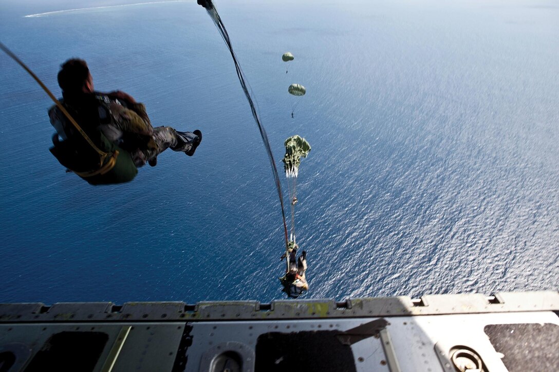 Soldiers execute static-line jumps out of a Marine-piloted KC-130J Hercules aircraft March 17 over the Tsuken Jima water drop zone near White Beach Naval Facility. The soldiers are with 1st Battalion, 1st Special Forces Group (Airborne). 