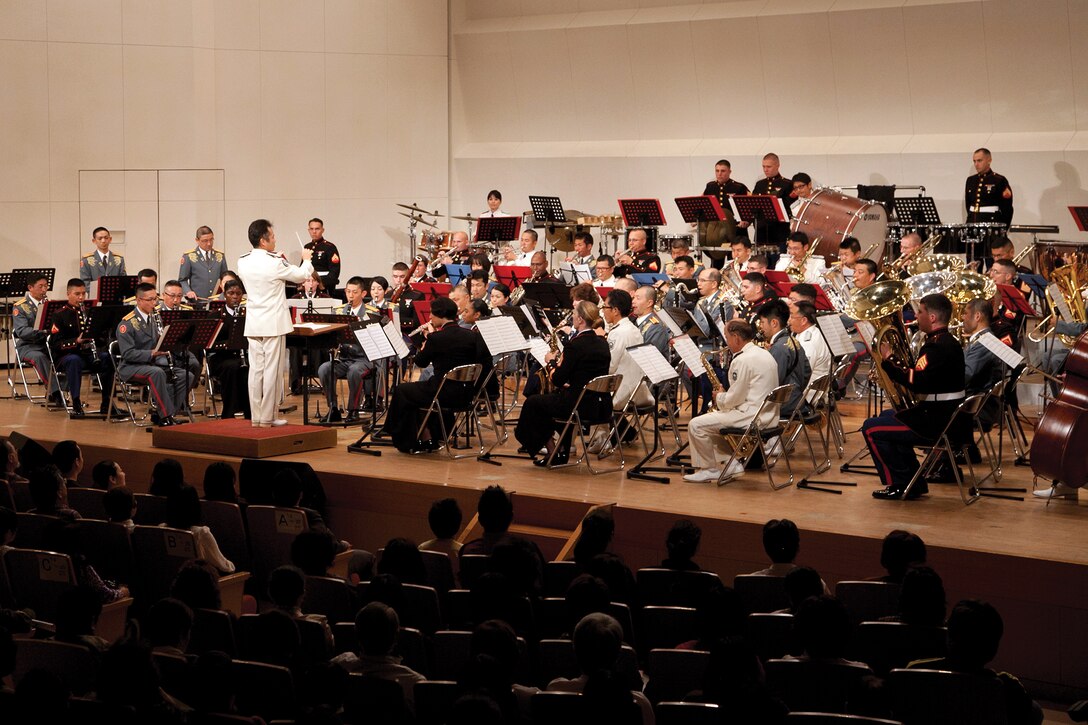 Japan Ground Self-Defense Force Capt. Tetsuya Sato conducts three bands March 17 during the 18th Annual Combined Concert at Tedako Hall in Urasoe City. The JGSDF 15th Band, Japan Air Self-Defense Force Southwestern Air Band and III Marine Expeditionary Force Band concluded the concert with a combined performance. Sato is the conductor of the JASDF Southwestern Air Band. 