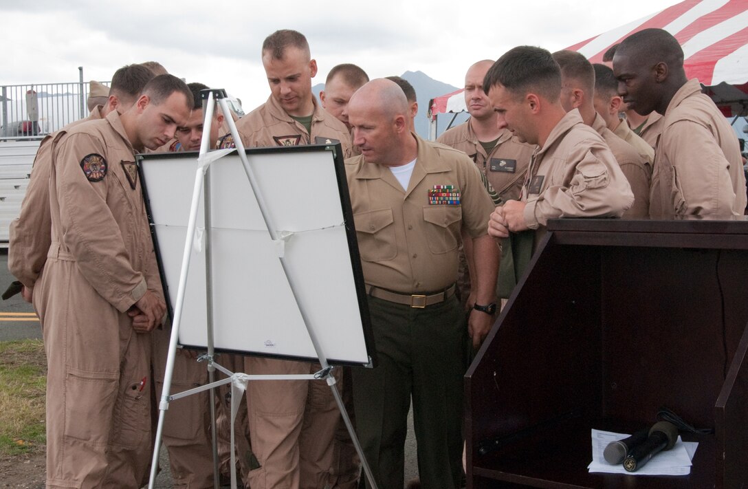 MARINE CORPS BASE HAWAII - Master Sgt. Daniel Sable (center), staff noncommissioned officer in charge of Aircraft Rescue and Firefighting, Marine Corps Air Station Kaneohe Bay, and ARFF Marines look over the artist's rendering of their soon-to-be new facility, after a groundbreaking ceremony for the MCAS Operations Complex, near the Aircraft Rescue and Firefighting building, March 15, 2013. The $46.6 million project includes a new terminal operations building, an ARFF building with individual dormitories for ARFF Marines, bays for fire trucks and office spaces. The complex is scheduled for completion in September 2014. (U.S. Marine Corps photo by Kristen Wong)