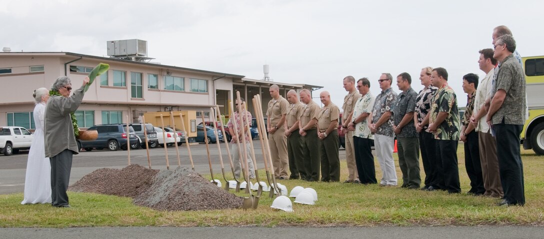 MARINE CORPS BASE HAWAII - Nalani Olds (left) and Kahu Likeke Papa perform a Hawaiian blessing during the groundbreaking ceremony for the Marine Corps Air Station Operations Complex, near the Aircraft Rescue and Firefighting building, March 15, 2013. The $46.6 million project includes a new terminal operations building, an ARFF building with individual dormitories for ARFF Marines, bays for fire trucks and office spaces. The complex is scheduled for completion in September 2014. (U.S. Marine Corps photo by Kristen Wong)