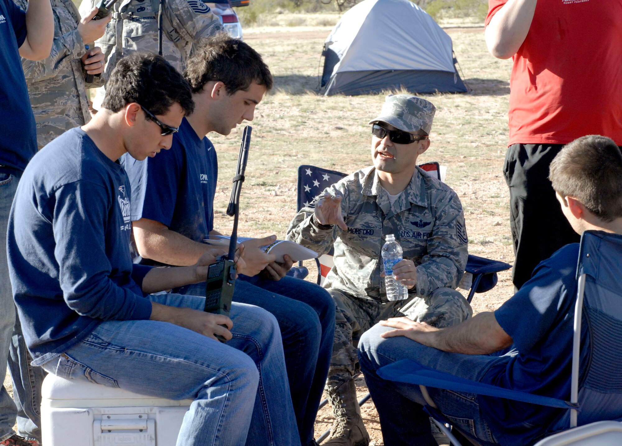 U.S. Air Force Tech. Sgt. Christopher Morford, 55th Rescue Squadron, gives instructions to his group of University of Arizona rugby team players in preparation for the search and rescue mission they will embark on at Davis-Monthan Air Force Base, Ariz., March 16, 2013. The trek was part of the mock deployment hosted by the 55th RQS. This is the third time this event has been hosted. (U.S. Air Force photo by Senior Airman Saphfire Cook/Released)