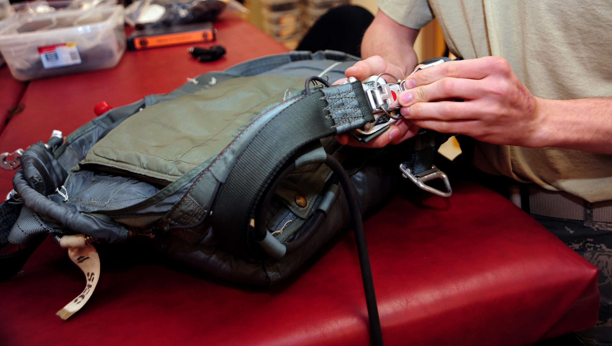 U.S. Air Force Senior Airman Alexander Klonowski, 43rd Electronic Combat Squadron aircrew flight equipment technician, performs a 30-day inspection on a parachute at Davis-Monthan Air Force Base, Ariz., March 20, 2013. A 30-day inspection consists of ensuring the oxygen cylinder is good and all tabs are in place. (U.S. Air Force photo by Senior Airman Camilla Griffin/Released)