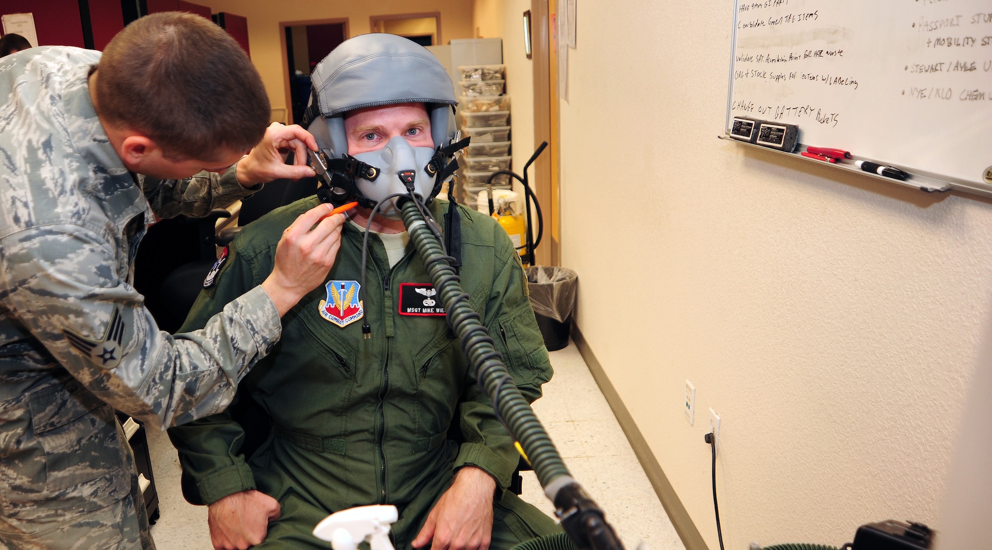 U.S. Air Force Senior Airman Alexander Klonowski, 43rd Electronic Combat Squadron aircrew flight equipment technician, fits Master Sergeant Michael Wiest, 43rd ECS cryptologic language analyst, for his helmet and mask at Davis-Monthan Air Force Base, Ariz., March 20, 2013. Helmets and mask are fitted once, with no expiration date, but are also inspected by an aircrew flight equipment member after every flight and every 90 days per Major Command. (U.S. Air Force photo by Senior Airman Camilla Griffin/Released)