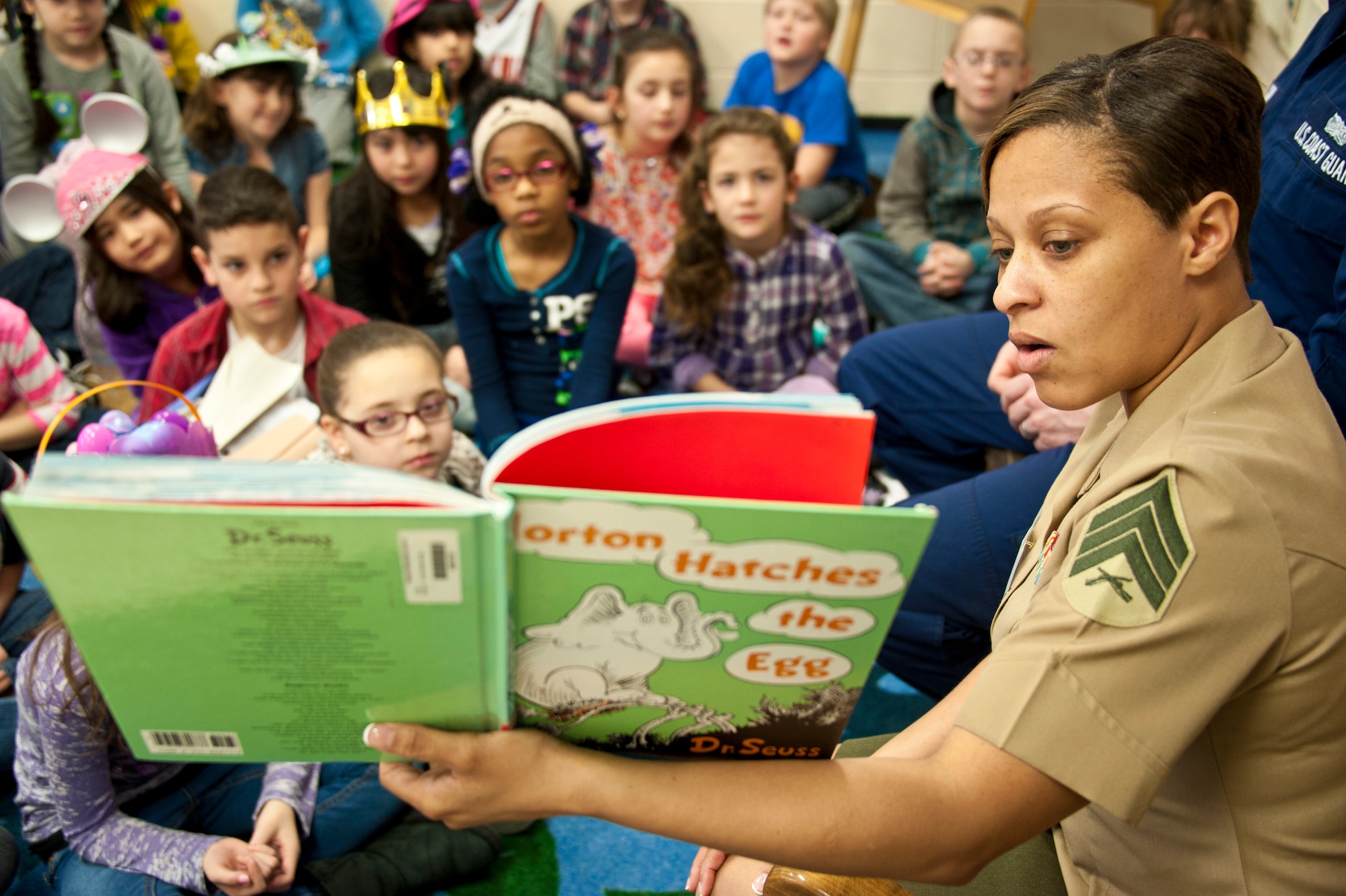 Sgt. Shree Hughes, Marine Aircraft Group 49 Legal Chief, reads Dr. Seuss’ “Horton Hatches the Egg” to Taunton Elementary School students during the Read Across America Day event March 20, 2013, in Howell Township, N.J. A group of 13 service members from every service branch and various career fields from Joint Base McGuire-Dix-Lakehurst, N.J., volunteered to read to the children at Taunton Elementary in an effort to continue the Read Across America Day tradition. Hughes is a Harrisburg, Pa., native. (U.S. Air Force photo by Staff Sgt. David Carbajal/Released)