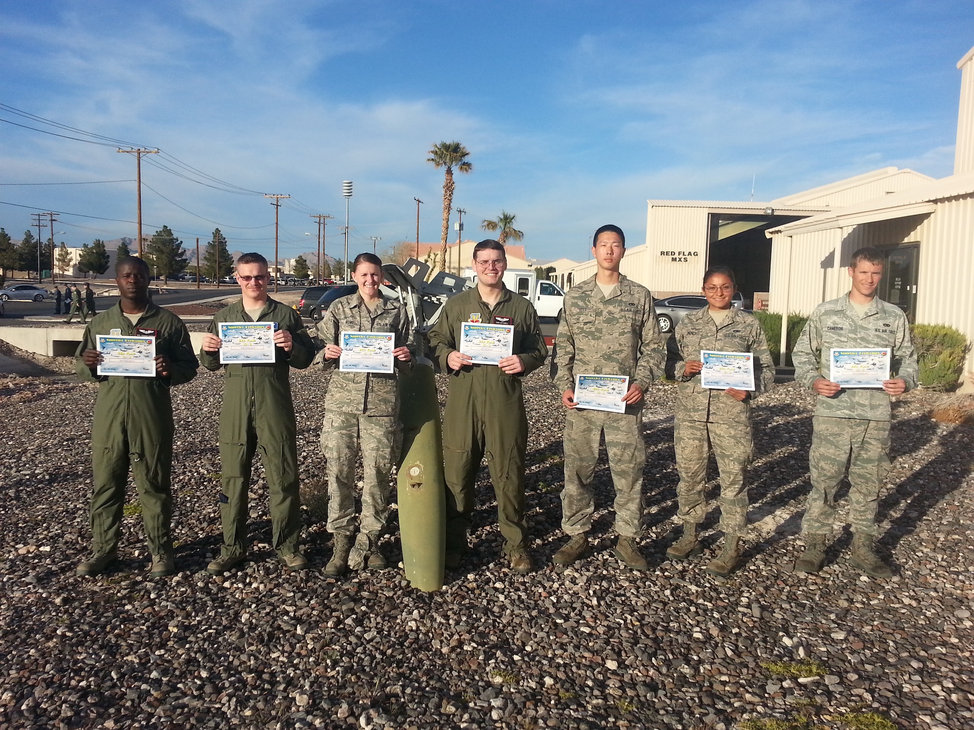 (From left) U.S. Air Force Senior Airman Tiderro Harmon, Staff Sgt Mark Cochrane, Senior Airman Bridget Rowe, 1st Lt. Daniel Mitchell, Senior Airman Timmon Reed, Airman 1st Class Diana Jiminez, and Senior Airman Joshua Cameron, all from the 55th Electronic Combat Group, stand with their certificates for superior performerance in the Red Flag 13-3 exercise. Along with Capt. Grant Kimmel and Staff Sgt Zachary Meyers, also from the 55th ECG, these Airmen were recognized out of 94 members from the 55th ECG who participated in Red Flag 13-3. (Courtesy photo/Released)