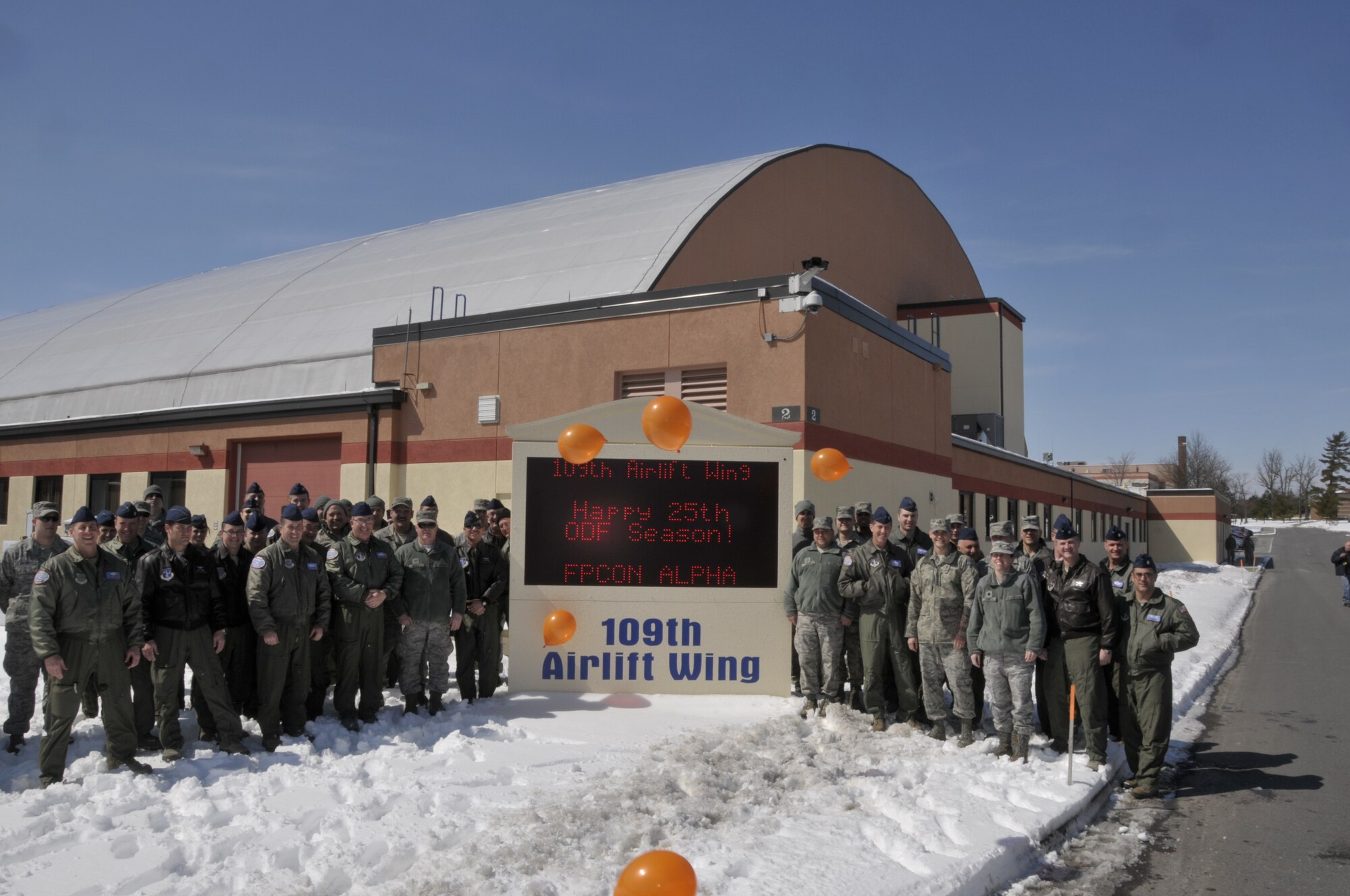 109th Airlift Wing members pose for a photo at the unit's sign in celebration of the unit's 25th year flying missions to Antarctica in support of Operation DEEP FREEZE at Stratton Air National Guard Base on March 21st, 2013. (USAF Photo by MSgt Willie Gizara/Released).