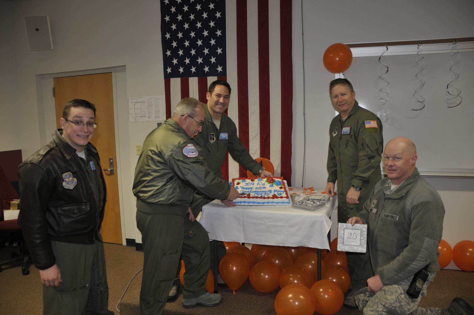 109th aircrew and aircraft maintaners cut a cake in celebration of the unit's 25th year flying missions to Antarctica in support of Operation DEEP FREEZE at Stratton Air National Guard Base on March 21st, 2013. (USAF Photo by MSgt Willie Gizara/Released) 