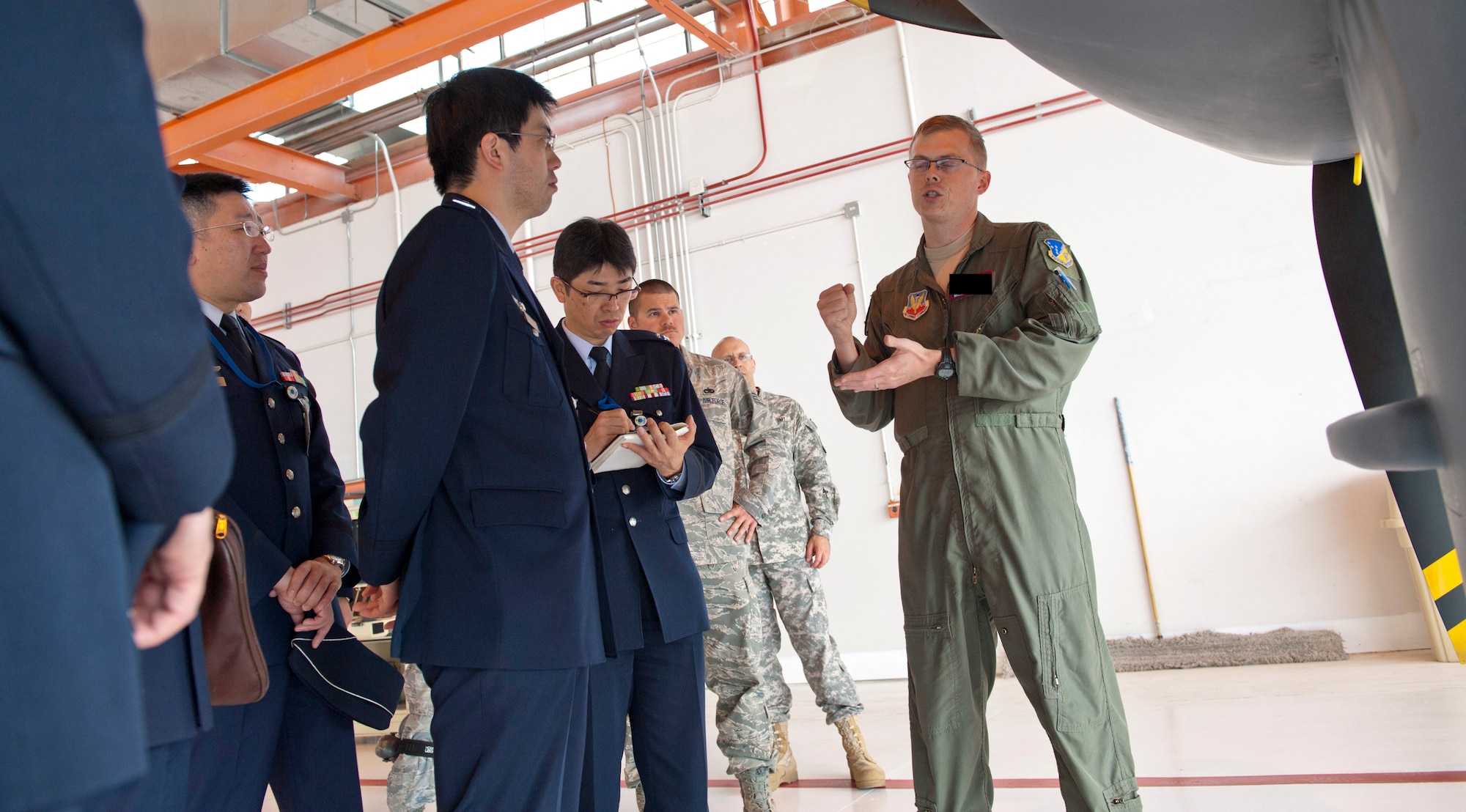 Major Michael (last name withheld due to operations security constraints), 9th Attack Squadron flight commander, explains the MQ-9 Reaper’s flight patterns to members of the Japan Air Self Defense Force at Holloman Air Force Base, N.M., March 19. The Remotely Piloted Aircraft program was briefed to the members of the Japan Air Self Defense Force. Their visit to Holloman AFB was part of an effort to bolster Japanese intelligence, surveillance and reconnaissance capability. (U.S. Air Force photo by Airman 1st Class Colin Cates/Released) 