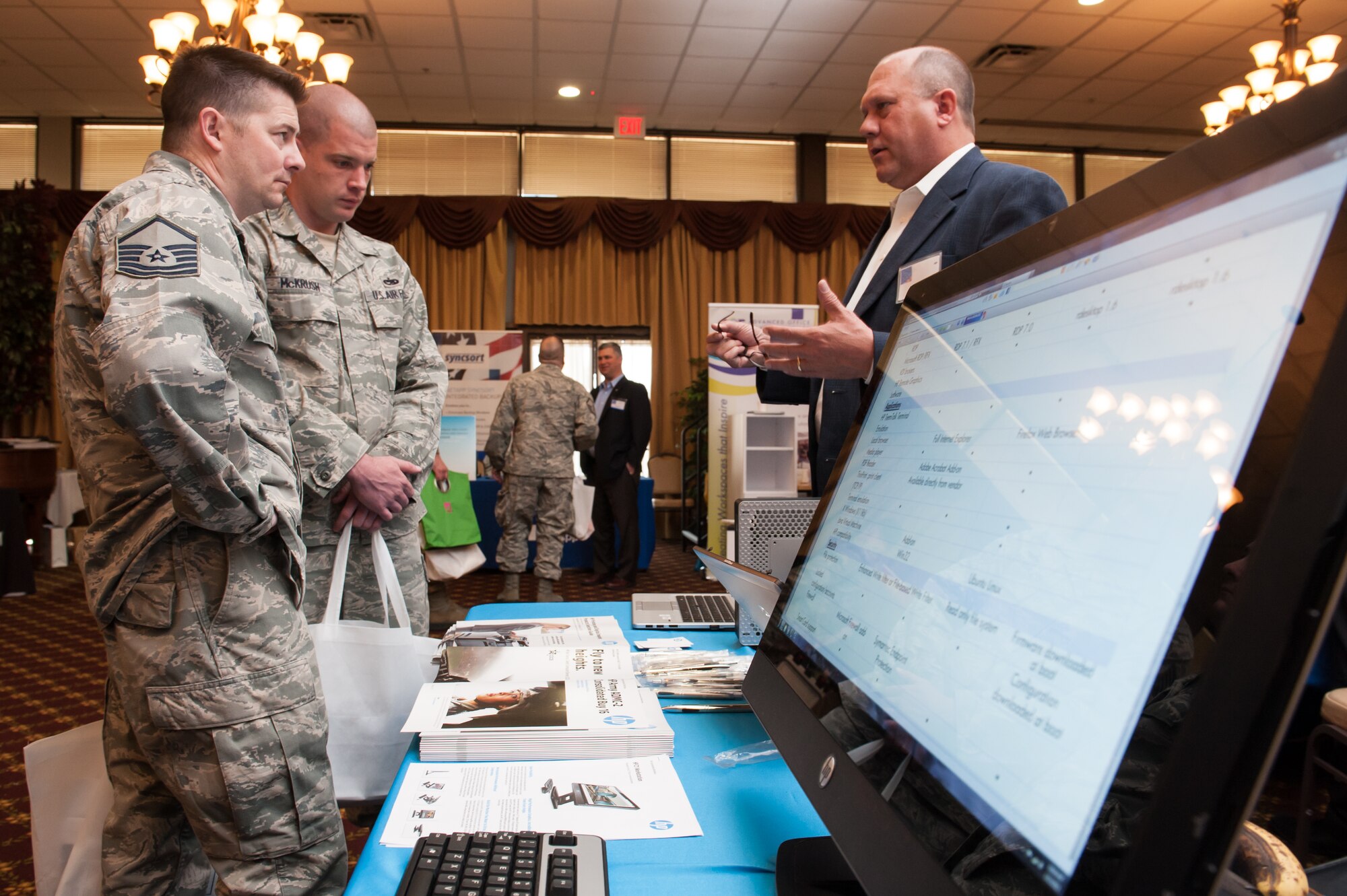 Mark Egloff, Hewlett-Packard Company U.S. Air Force account manager provides information to Master Sgt. Ronald Logan, 305th Maintenance Squadron test, measurement and diagnostic equipment flight chief, and Tech Sgt. Thomas McKrush, 305th MXS NCOIC precision measurement equipment laboratory NCO in-charge, Mar. 13, 2013, at the 5th Annual Joint Base McGuire-Dix-Lakehurst Information Technology Expo at JB MDL, N.J. The event offered more than 50 vendors the opportunity to provide information to attendees. Logan hails from Connellsville Pa. and McKrush hails from Johnstown, Pa. (U.S. Air Force photo by Russ Meseroll/Released)