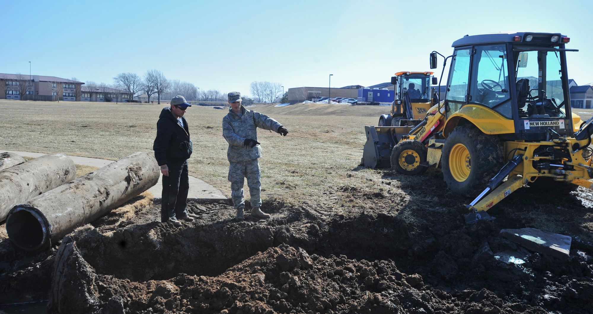 Bobby Wren and Staff Sgt. Andrew Wise, 22nd Civil Engineer Squadron heavy equipment operators, discuss the next step during a culvert replacement March 7, 2013, McConnell Air Force Base, Kan. The construction was designed to replace a failing culvert outside of Building 1 and to fix a broken sidewalk. (U.S. Air Force photo/Airman 1st Class Colby L. Hardin)