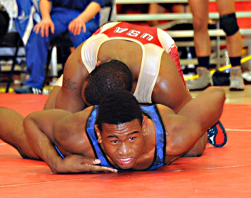 Air Force Brandon Johnson brandishes a bloody lip as he defends against Army Justin Lester’s attempt at a gut wrench in the 74 kg freestyle match March 17. Johnson is stationed at Ramstein Air Base, Germany. He calls Moreno Valley, Calif., home. Lester is stationed at Fort Carson, Colo., and calls Akron, Ohio, home. (U.S. Air Force photo by Senior Master Sgt. Denise Johnson/Released)