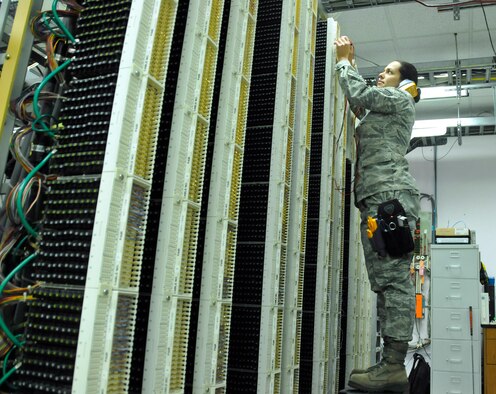 Senior Airman Sharon Navarro, 482nd Communications Squadron Knowledge Operations Manager, checks for dial tone after connecting a new phone line in the Telephone Central Office at Homestead Air Reserve Base, Fla., Mar. 14. The Telephone Central Office hosts all of Homestead ARB's phone lines, alarm circuits, commercial communications lines, and television services. (U.S. Air Force photo/Senior Airman Nicholas Caceres)