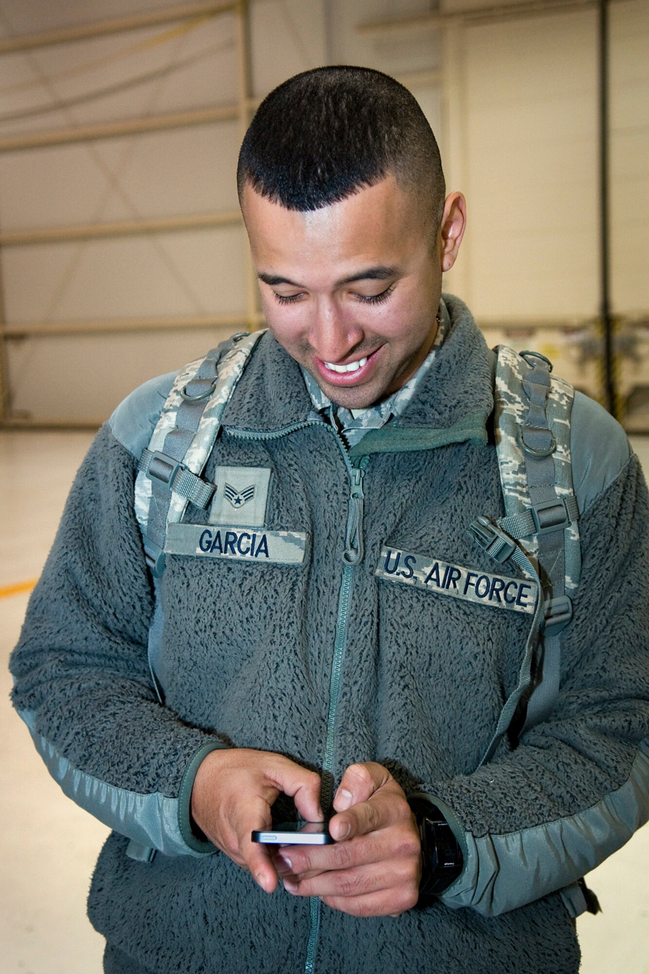 GRISSOM AIR RESERVE BASE, Ind. -- Senior Airman Daniel Garcia, 434th Security Forces Squadron fire team member, texts a friend as he arranges to surprise his girlfriend at her work after returning from a six-month deployment to the Transit Center at Manas, Kyrgyzstan, March 6. Garcia and 20 other security forces Airmen deployed for six months to provide security for the base. (U.S. Air Force photo/Tech. Sgt. Mark R. W. Orders-Woempner)
