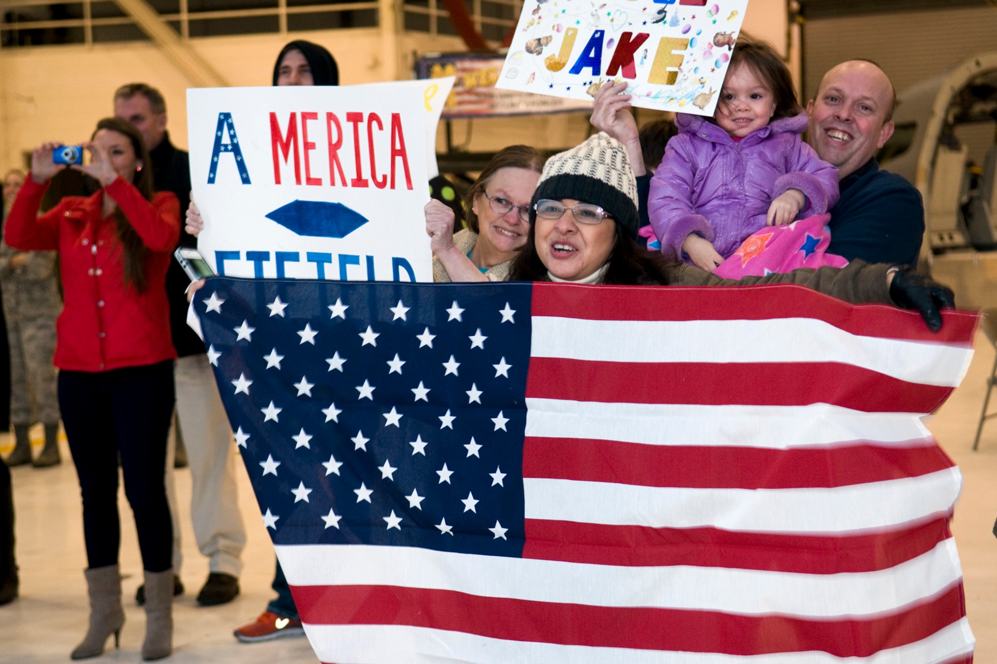 GRISSOM AIR RESERVE BASE, Ind. -- Marta Iscoa, mother of Senior Airman Jessie Eastham, holds up an American flag as she and other family members and friends of 21 434th Security Forces Squadron Airmen welcome home their loved ones after a six-month deployment to the Transit Center at Manas, Kyrgyzstan, March 6. Eastham is a fire team member with the unit. (U.S. Air Force photo/Tech. Sgt. Mark R. W. Orders-Woempner)
