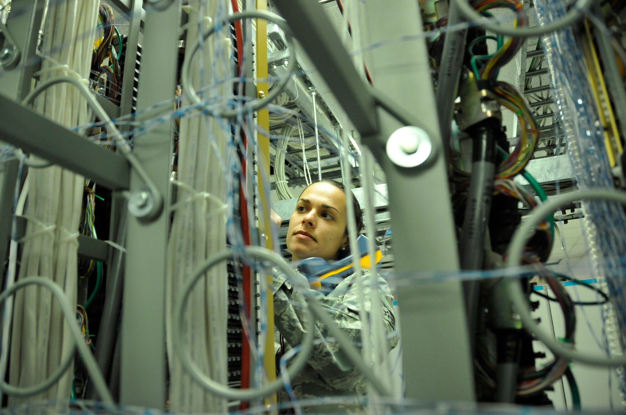 Senior Airman Sharon Navarro, 482nd Communications Squadron Knowledge Operations Manager, checks for dial tone after connecting a new phone line in the Telephone Central Office at Homestead Air Reserve Base, Fla., Mar. 14. The Telephone Central Office hosts all of Homestead ARB's phone lines, alarm circuits, commercial communications lines, and television services. (U.S. Air Force photo/Nicholas Caceres)
