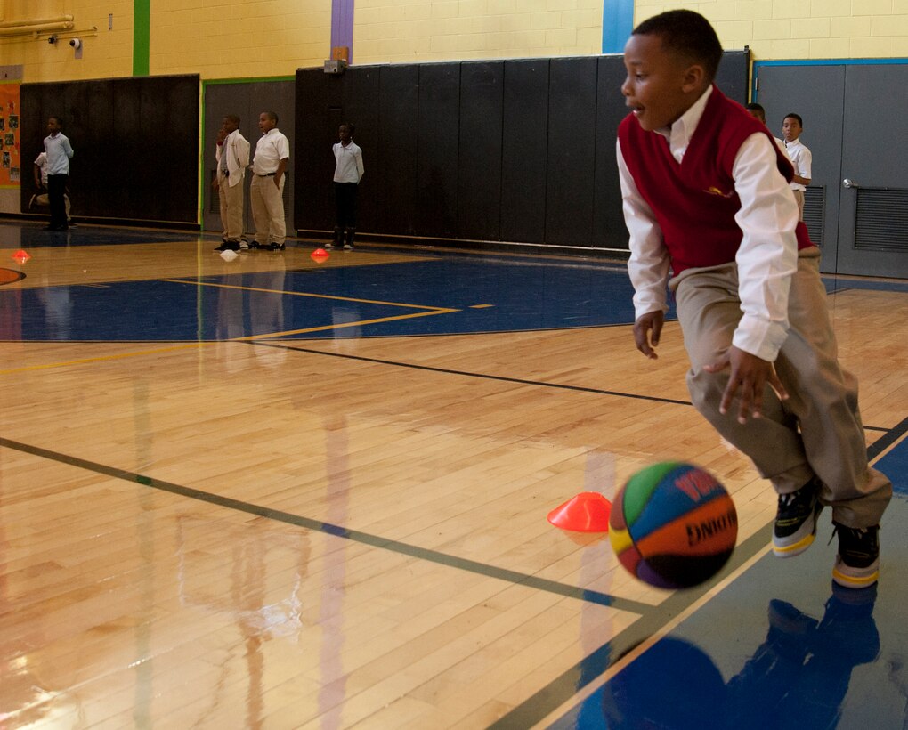 Rayvon Wilkerson dribbles around an obstacle during a competition at the Joint Base Andrews Youth Center March 19, 2013.  The gym was recently renovated and the youth center hosted an open house to celebrate the completion of the three-month long project. (U.S. Air Force photo/Staff Sgt. Torey Griffith)