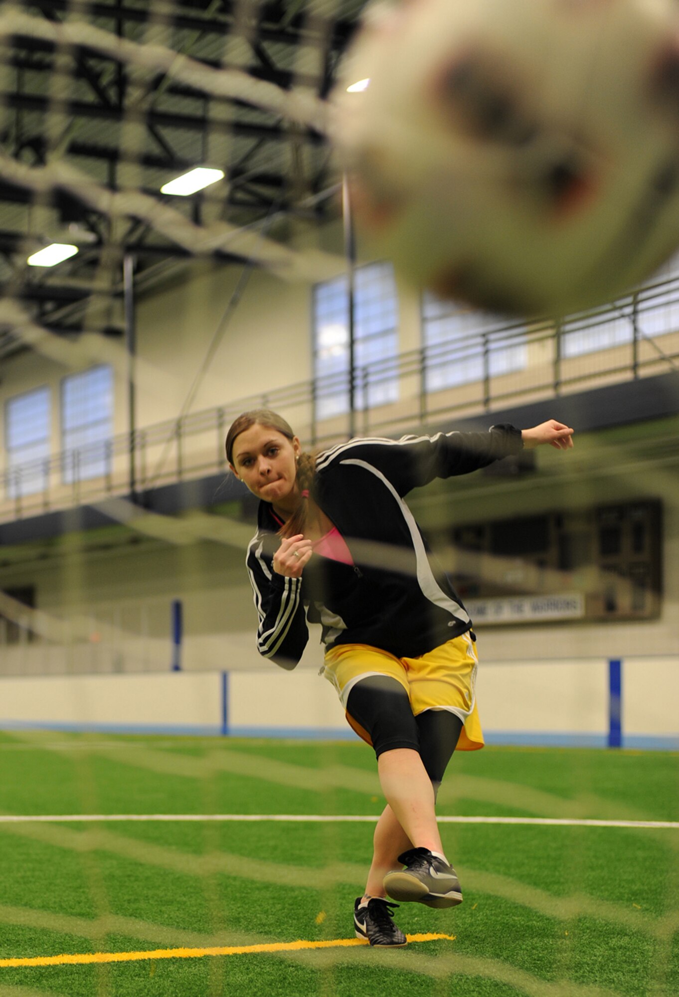 Airman 1st Class Ashley Taylor kicks a ball into one of the goals of the indoor soccer field on Grand Forks Air Force Base, N.D., on March 20, 2013. Taylor was selected as Grand Fork’s AFB’s Warrior of the Week for the third week of March 2013. She was also nominated for Team Grand Forks Female Athlete of the Year. (U.S. Air Force photo/Airman 1st Class Xavier Navarro)