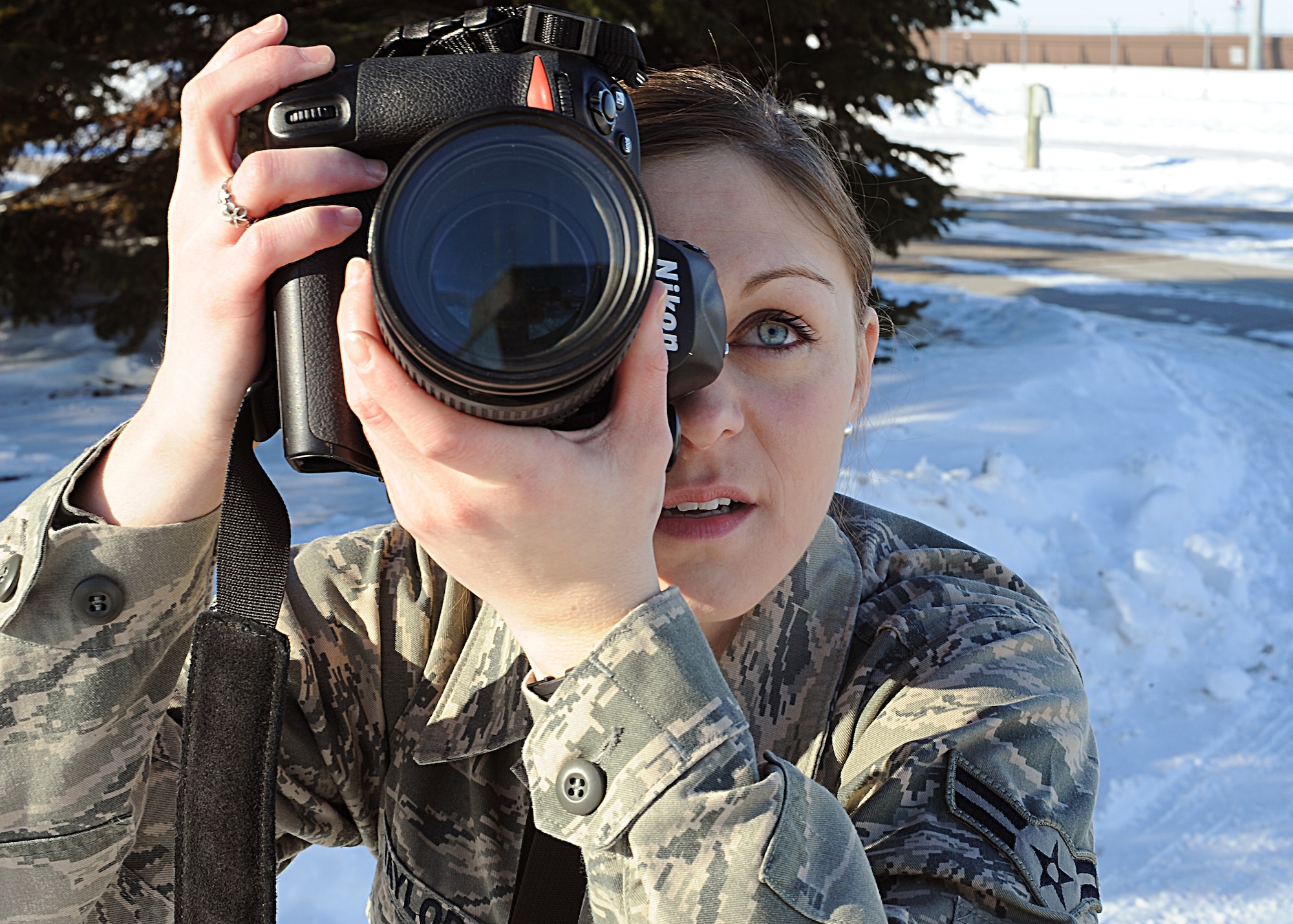 Airman 1st Class Ashley Taylor adjusts her camera lens to snap another action photo March 21, 2013, at Grand Forks Air Force Base, N.D. Taylor was selected as Grand Fork’s AFB’s Warrior of the Week for the third week of March 2013. As an Air Force photojournalist, the 22-year-old native from Junction City, Kan., produced more than 4,200 media products in 2012. (U.S. Air Force photo/Airman 1st Class Xavier Navarro)